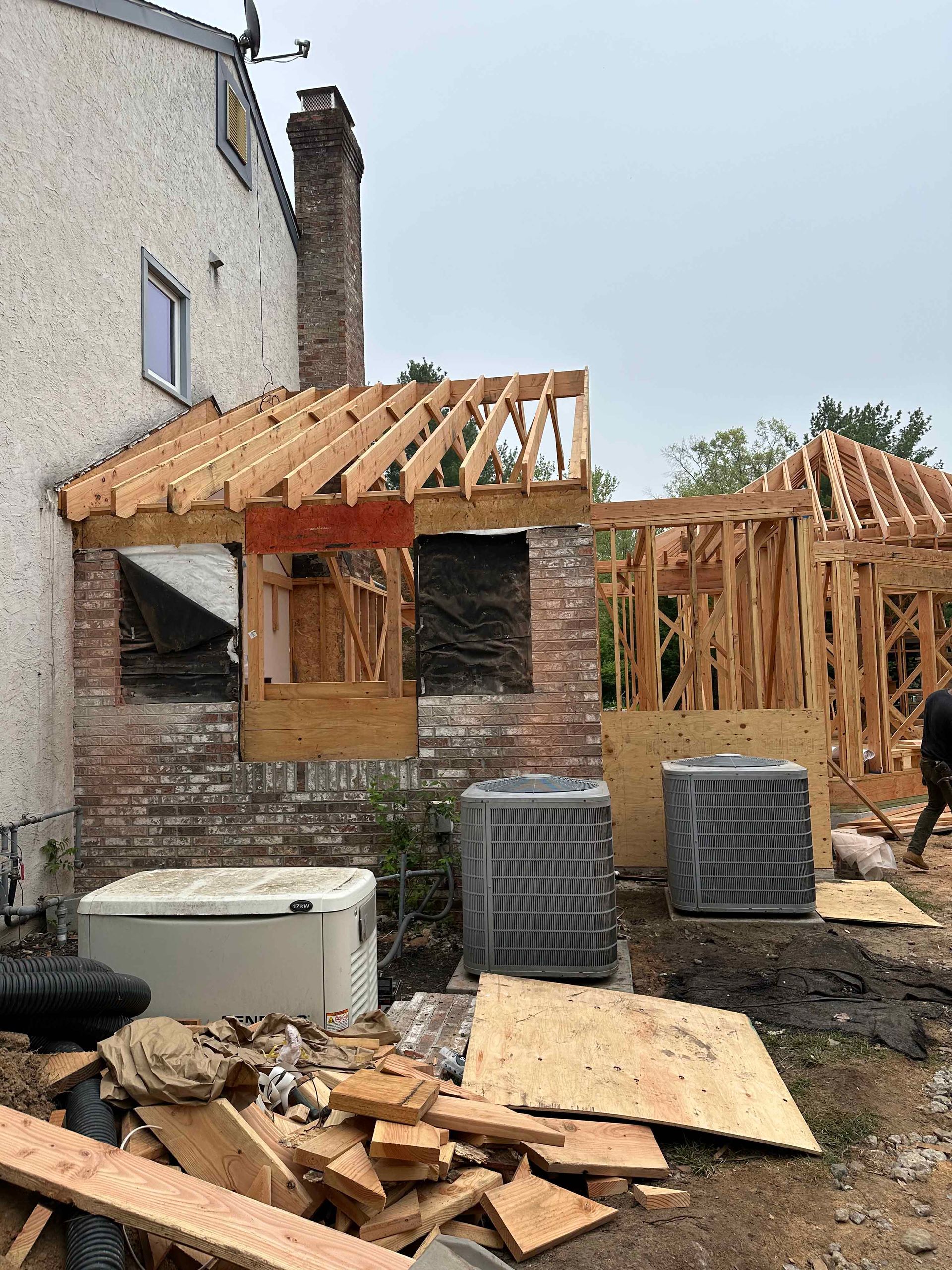 A man is standing in front of a house under construction.