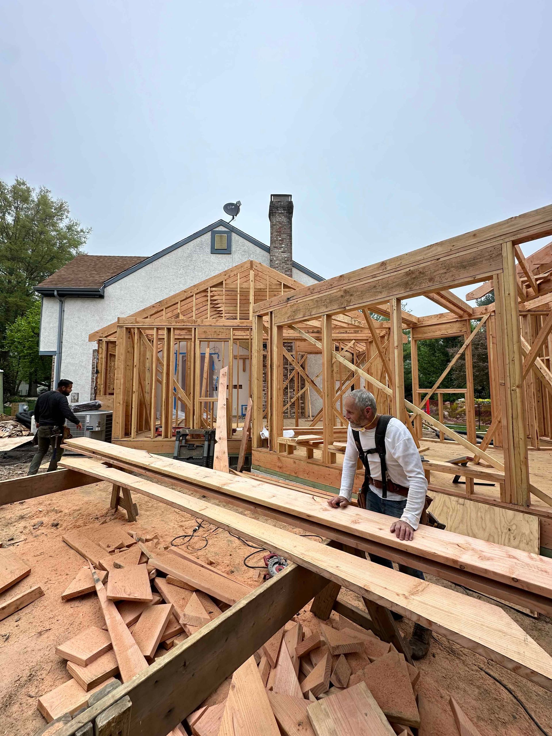 A man is working on a wooden structure at a construction site.