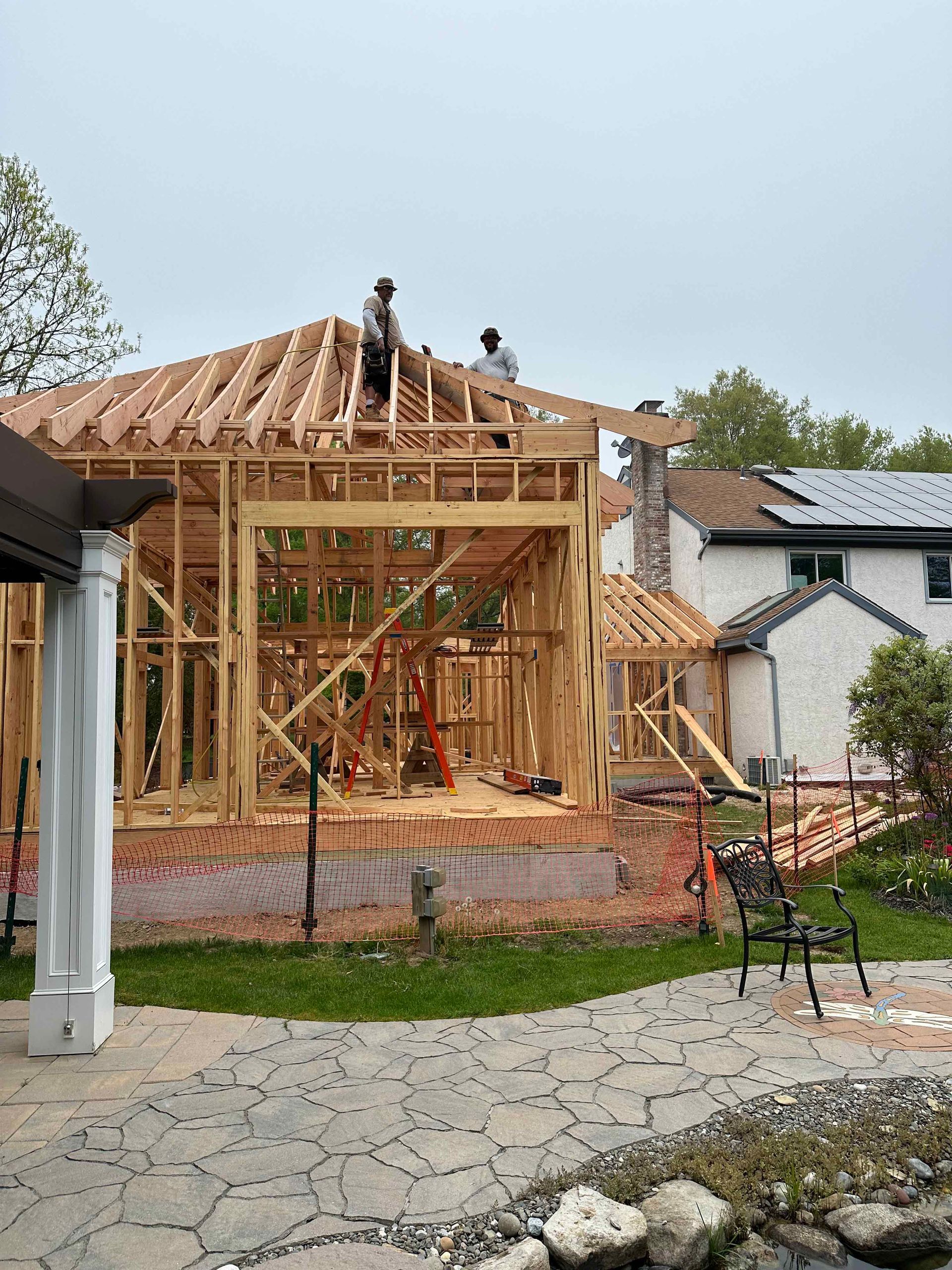 A house is being built with wooden beams and a roof.