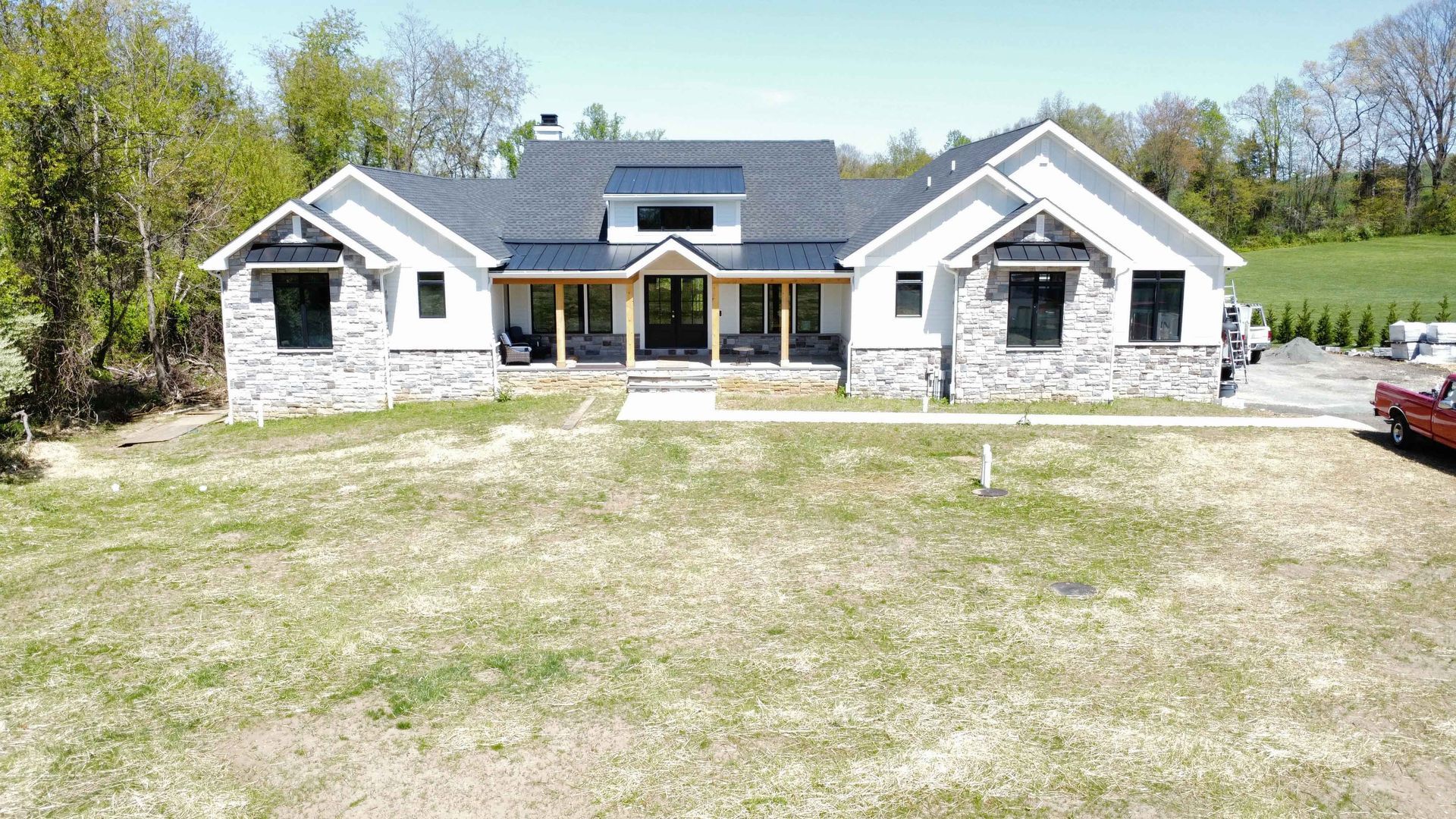 An aerial view of a large house with a car parked in front of it.