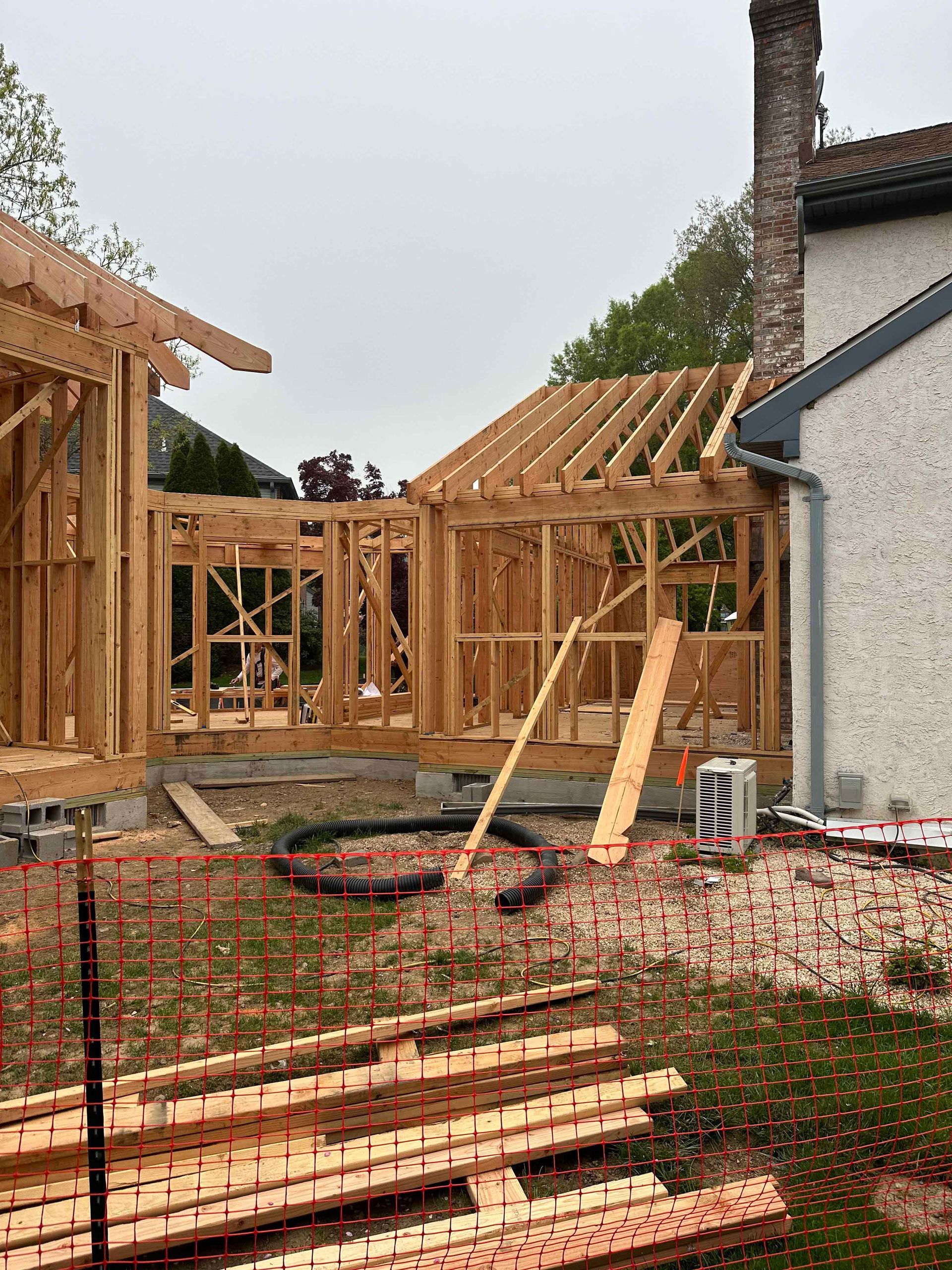 A house is being built with wooden beams and a chimney.