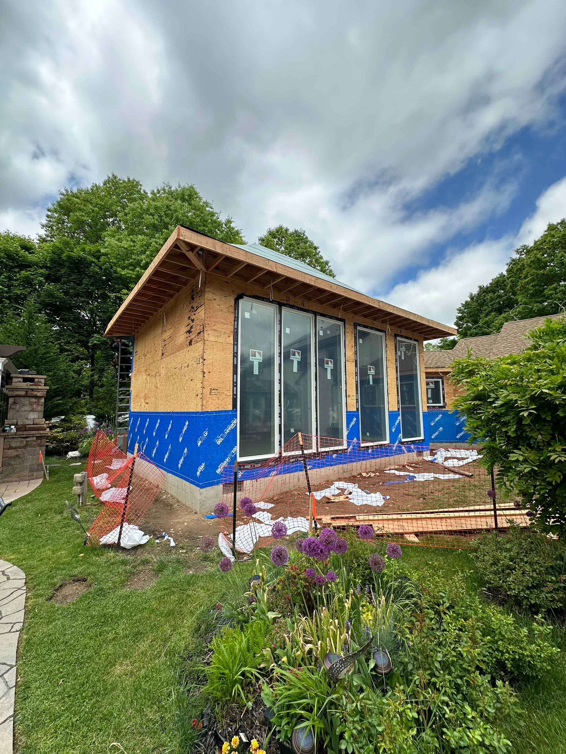 A small house is being built in the backyard of a house.