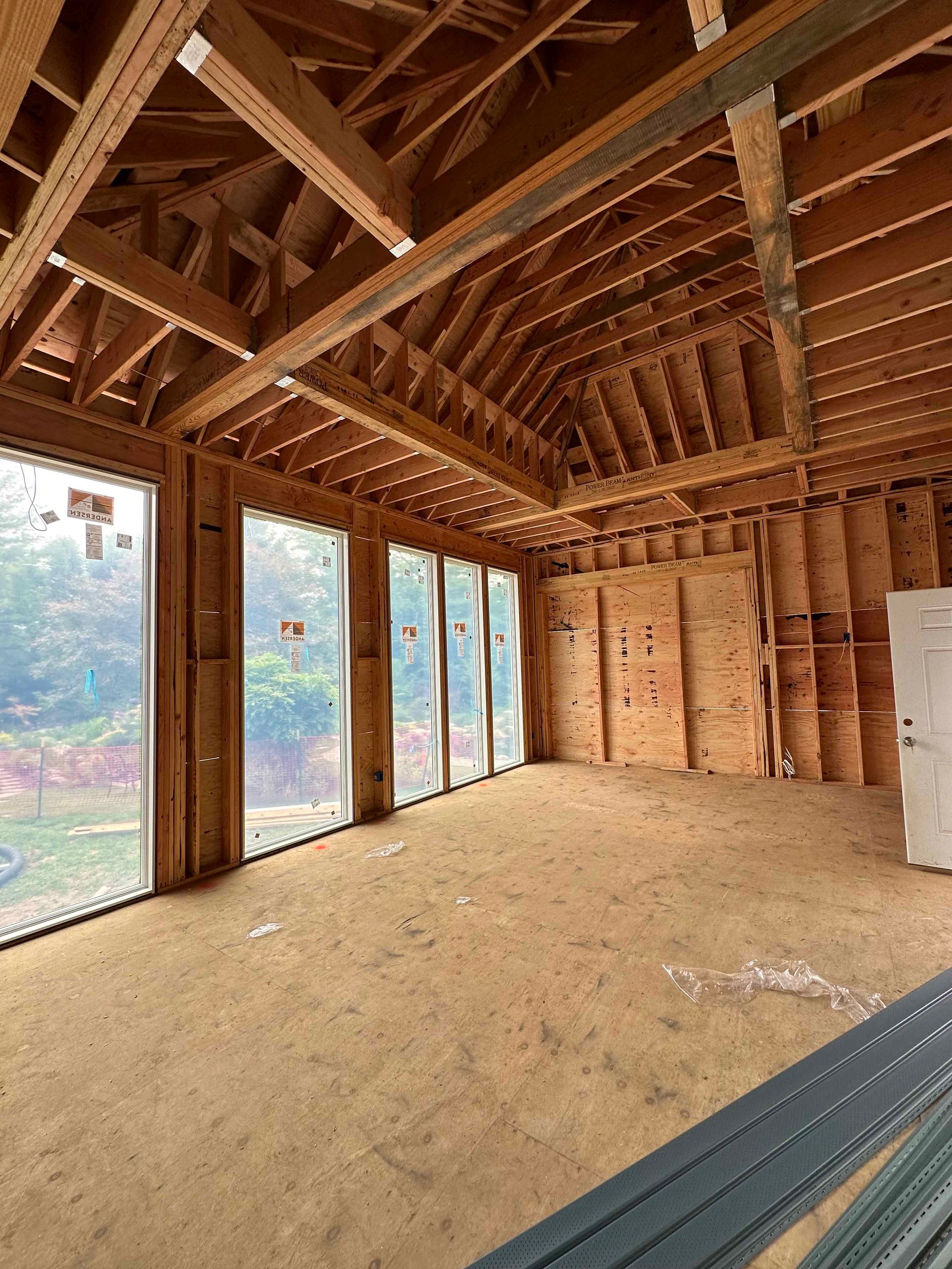 A large room with a lot of windows and wooden beams.