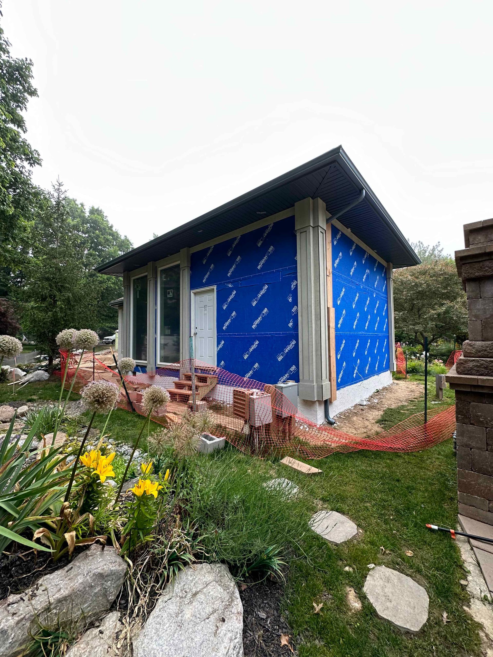 A small house is being built in the backyard of a house.