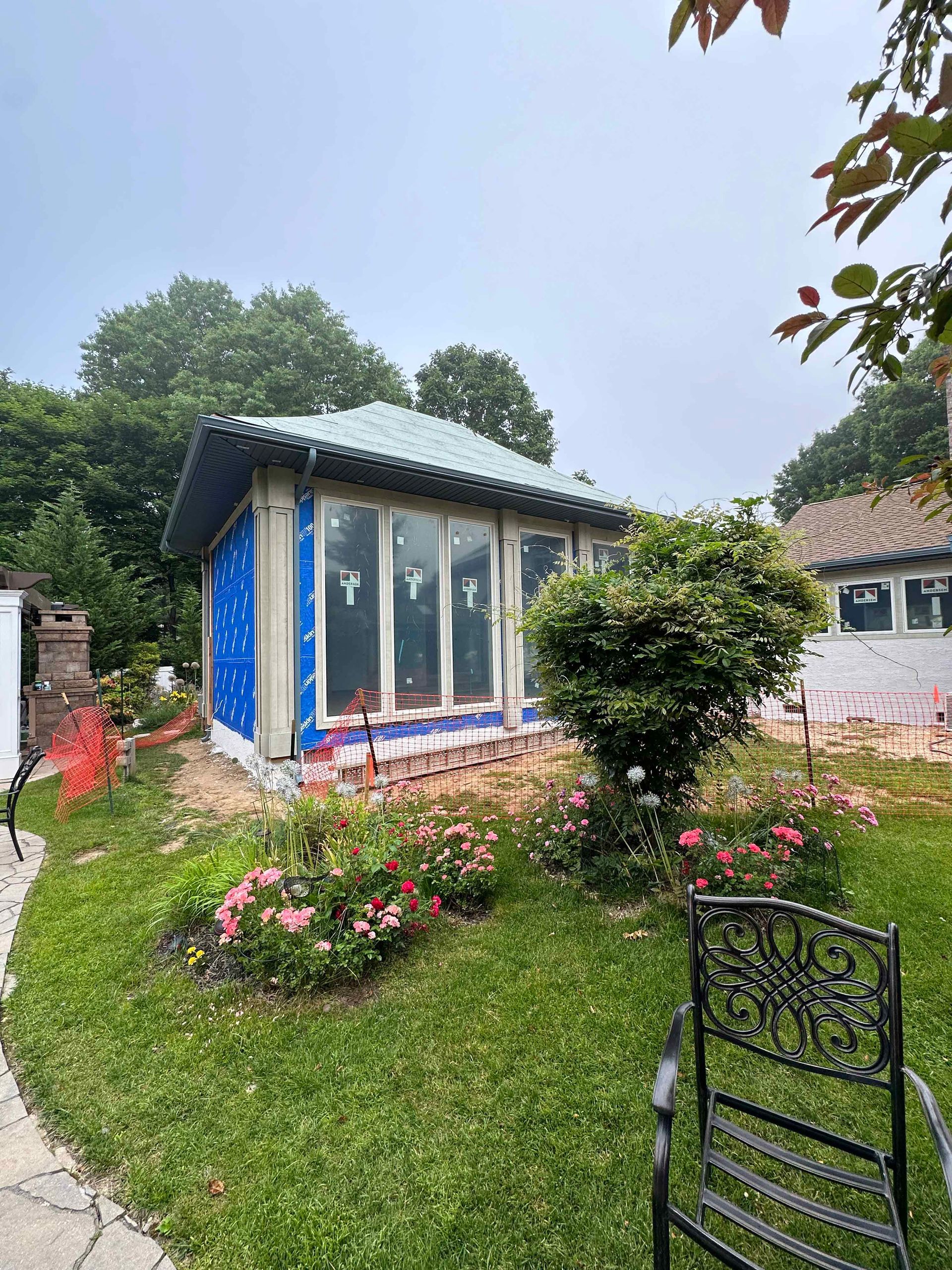 A small house is being built in the backyard of a house.