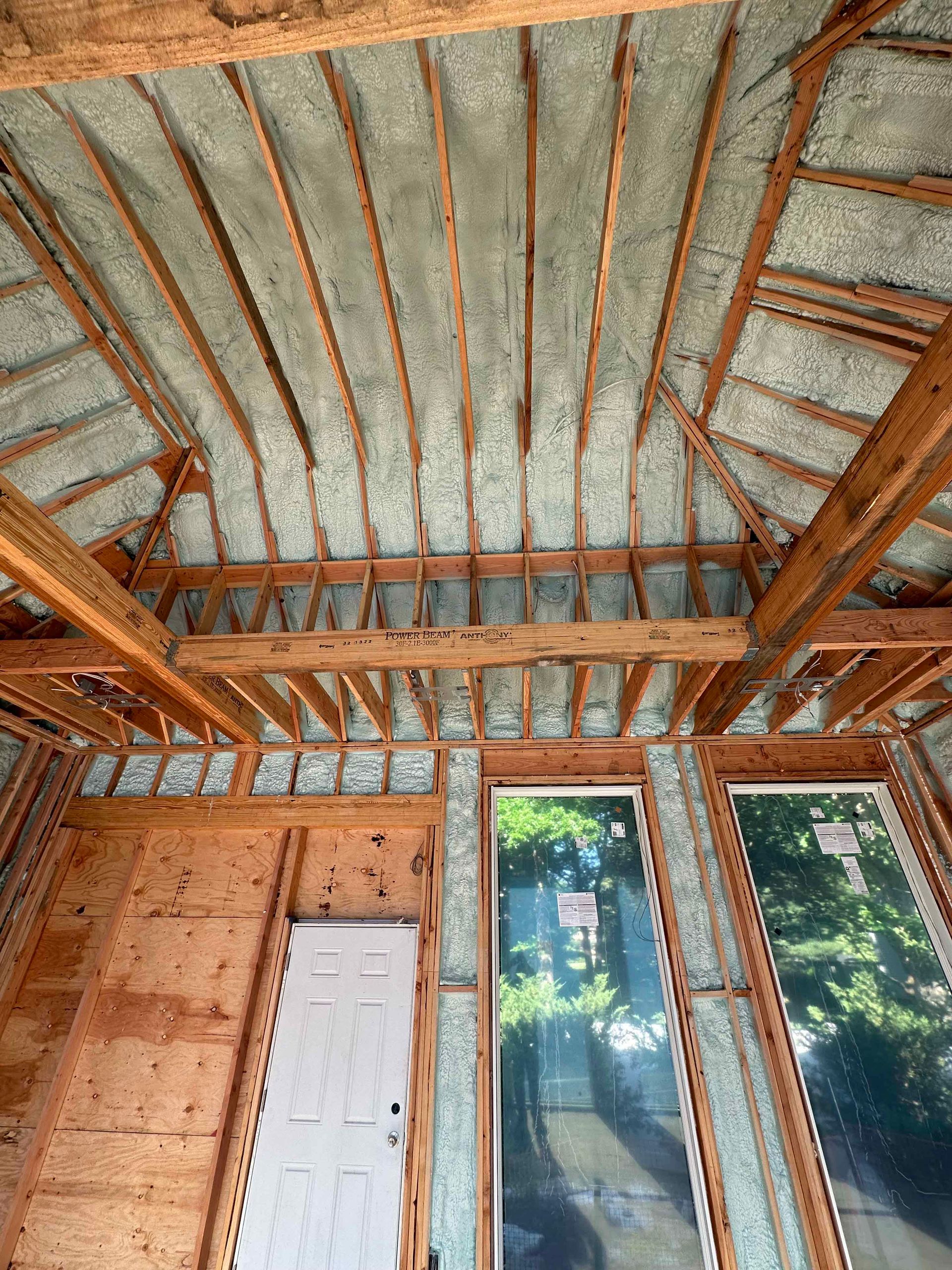 The ceiling of a house is being insulated with spray foam.