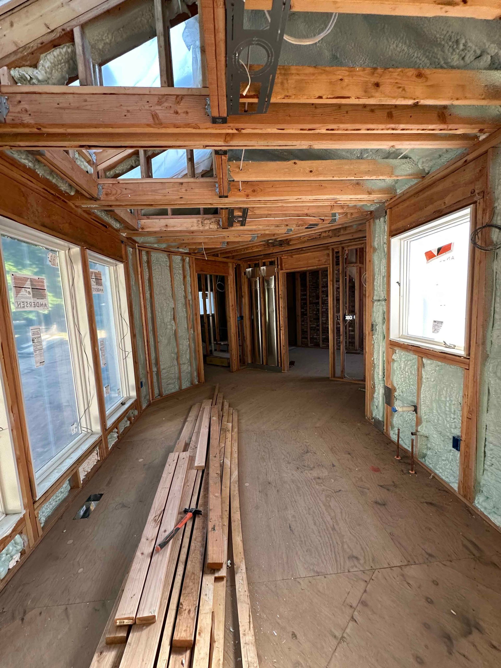 A large room with a lot of windows and wooden beams.