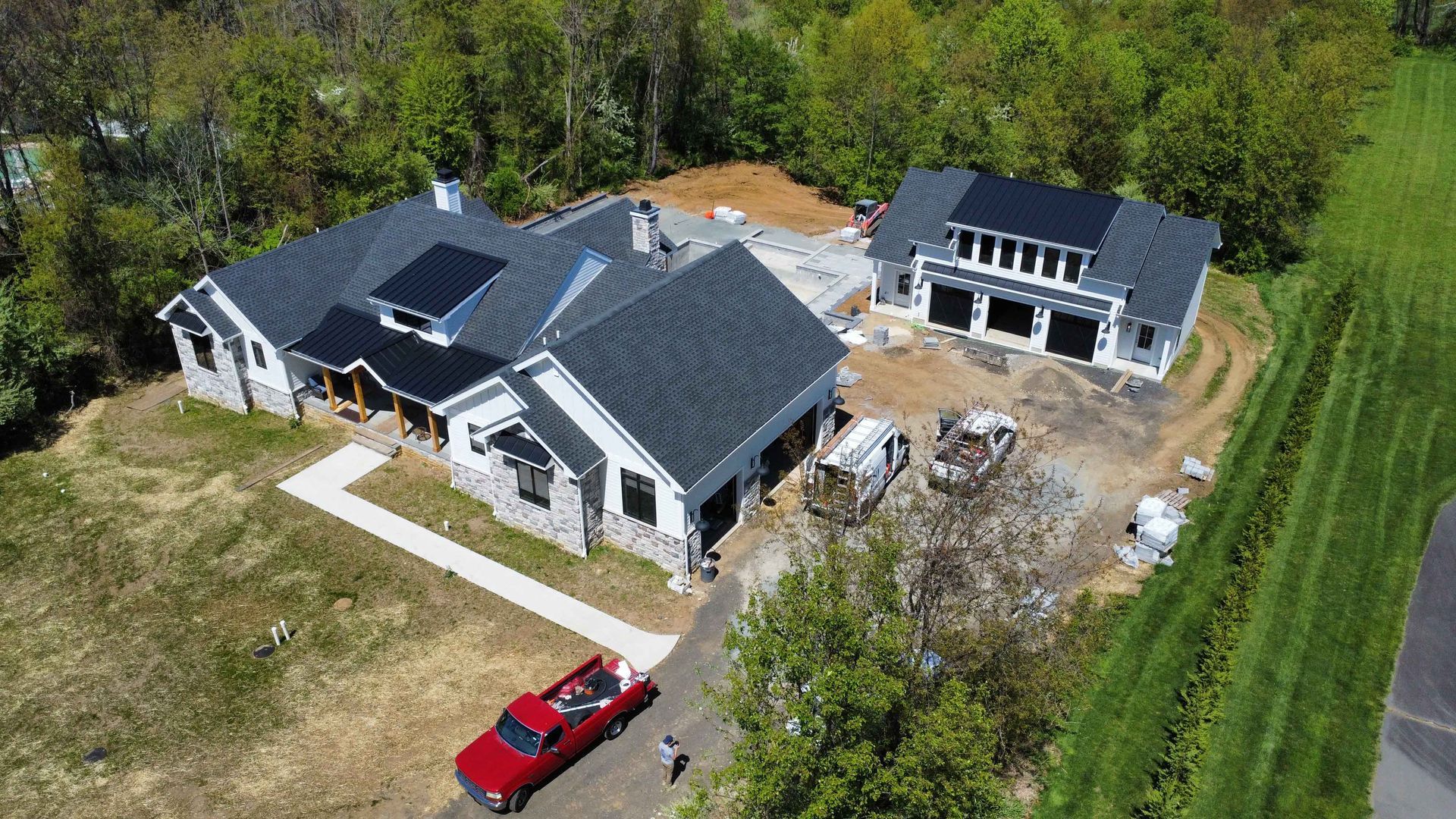 An aerial view of a house under construction with a red truck parked in front of it.