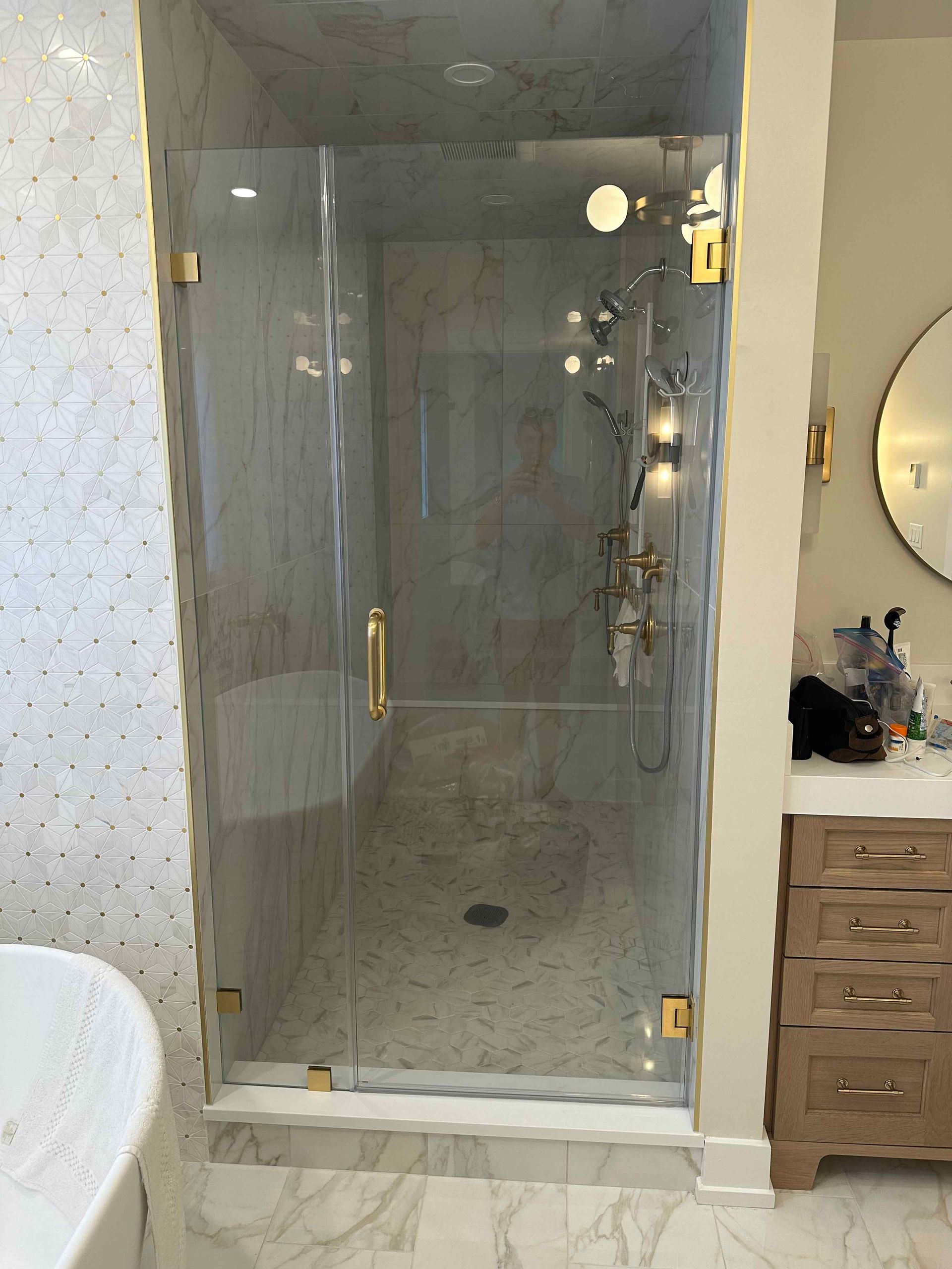 A bathroom with a walk in shower and a sink.