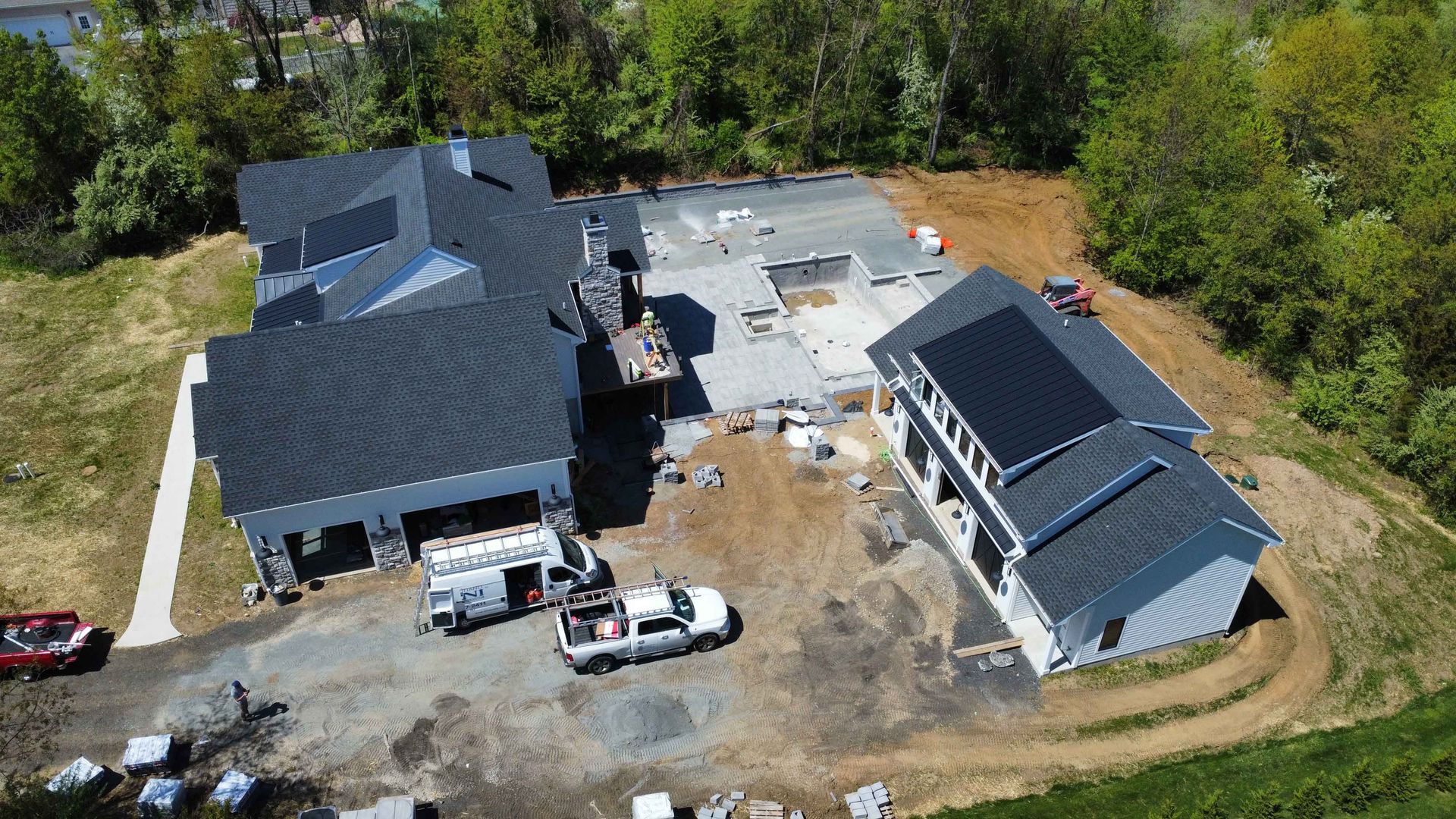 An aerial view of a house under construction with solar panels on the roof.