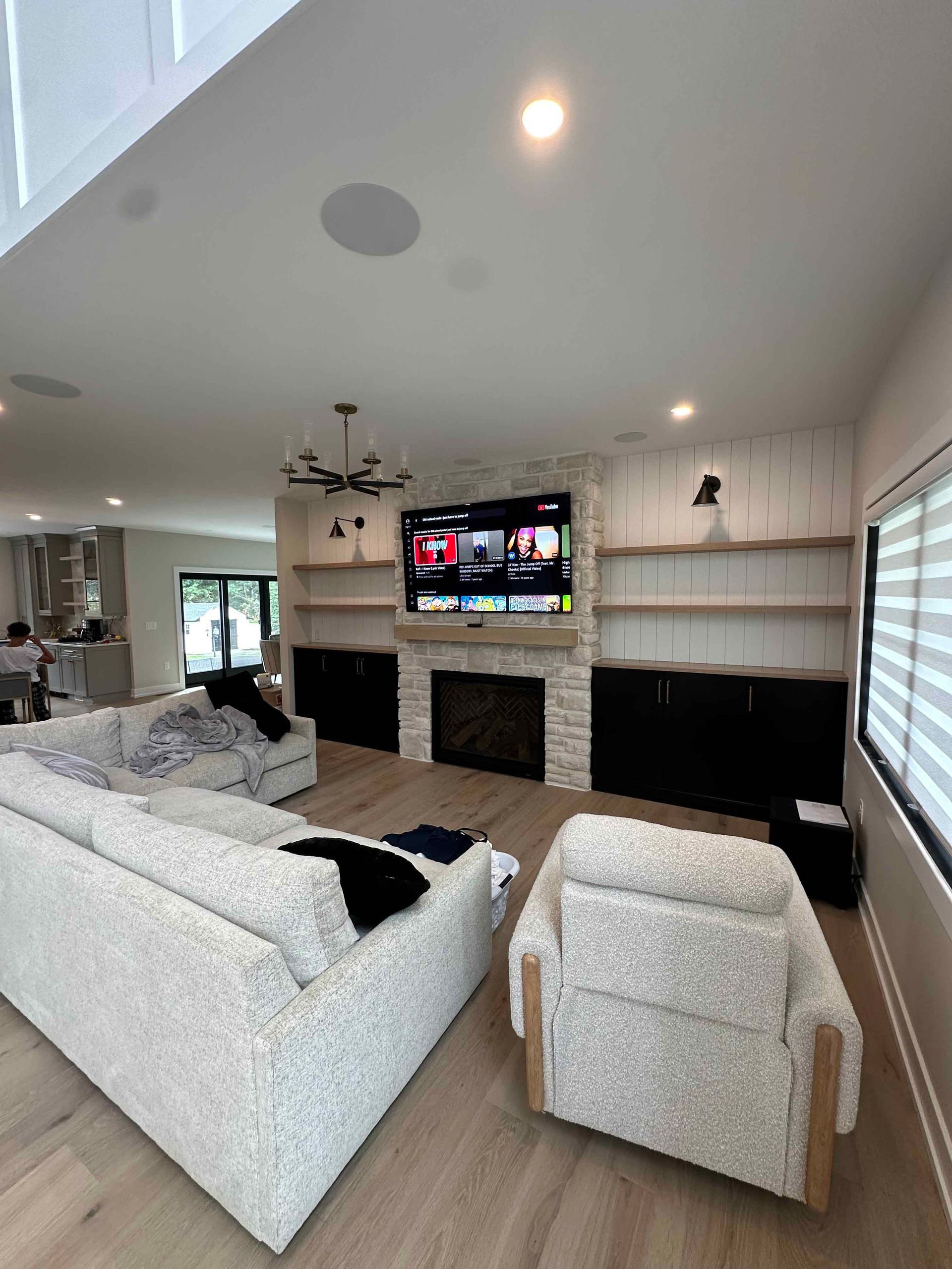 A living room with a couch , chairs , fireplace and television.
