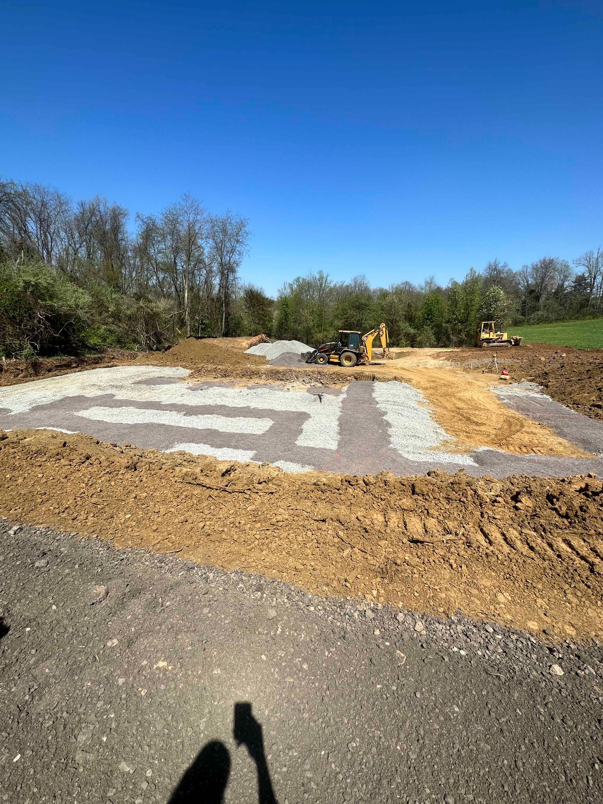 A person is standing in the middle of a dirt field.
