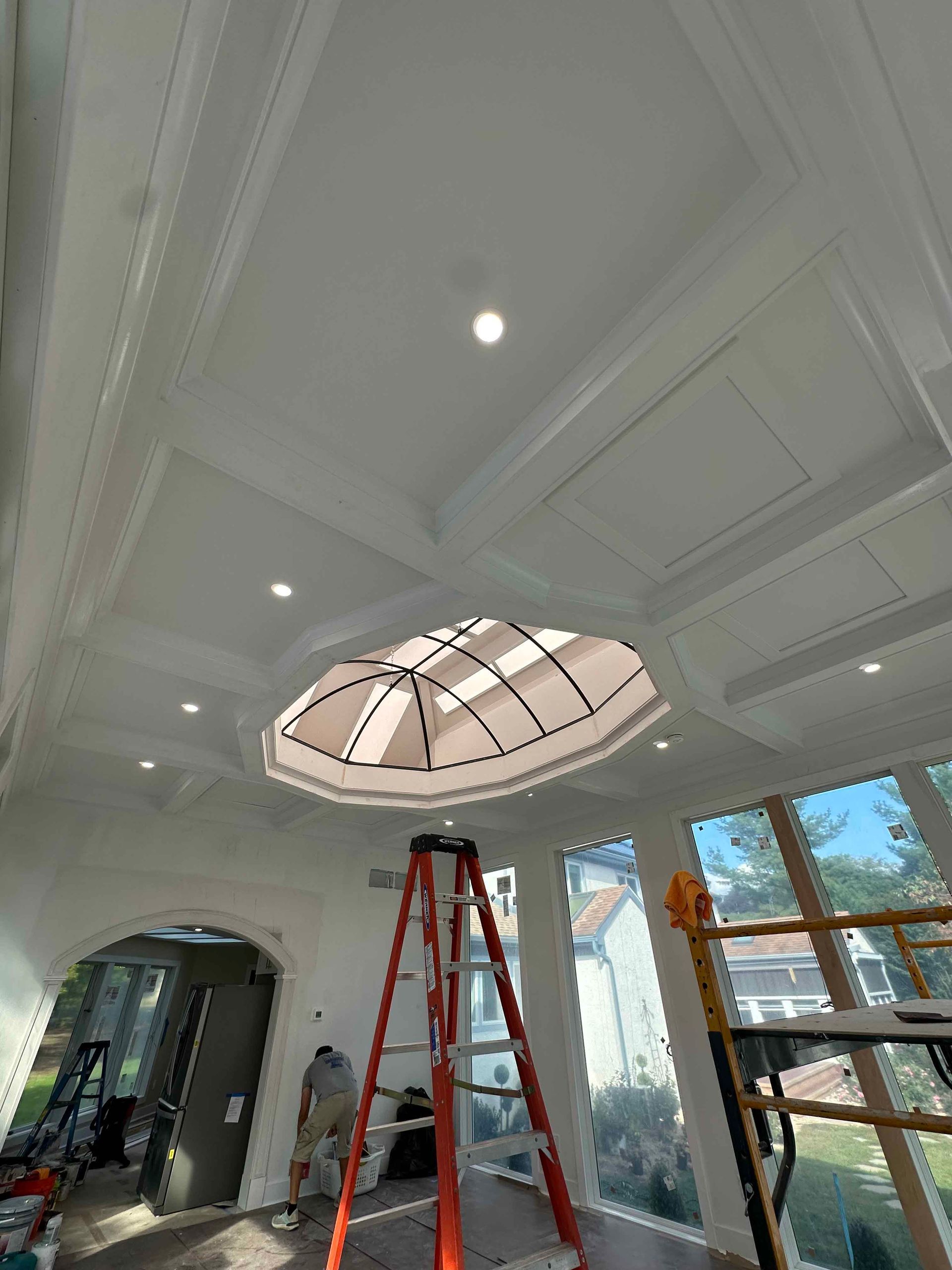 A ladder is sitting in a room with a dome in the ceiling.