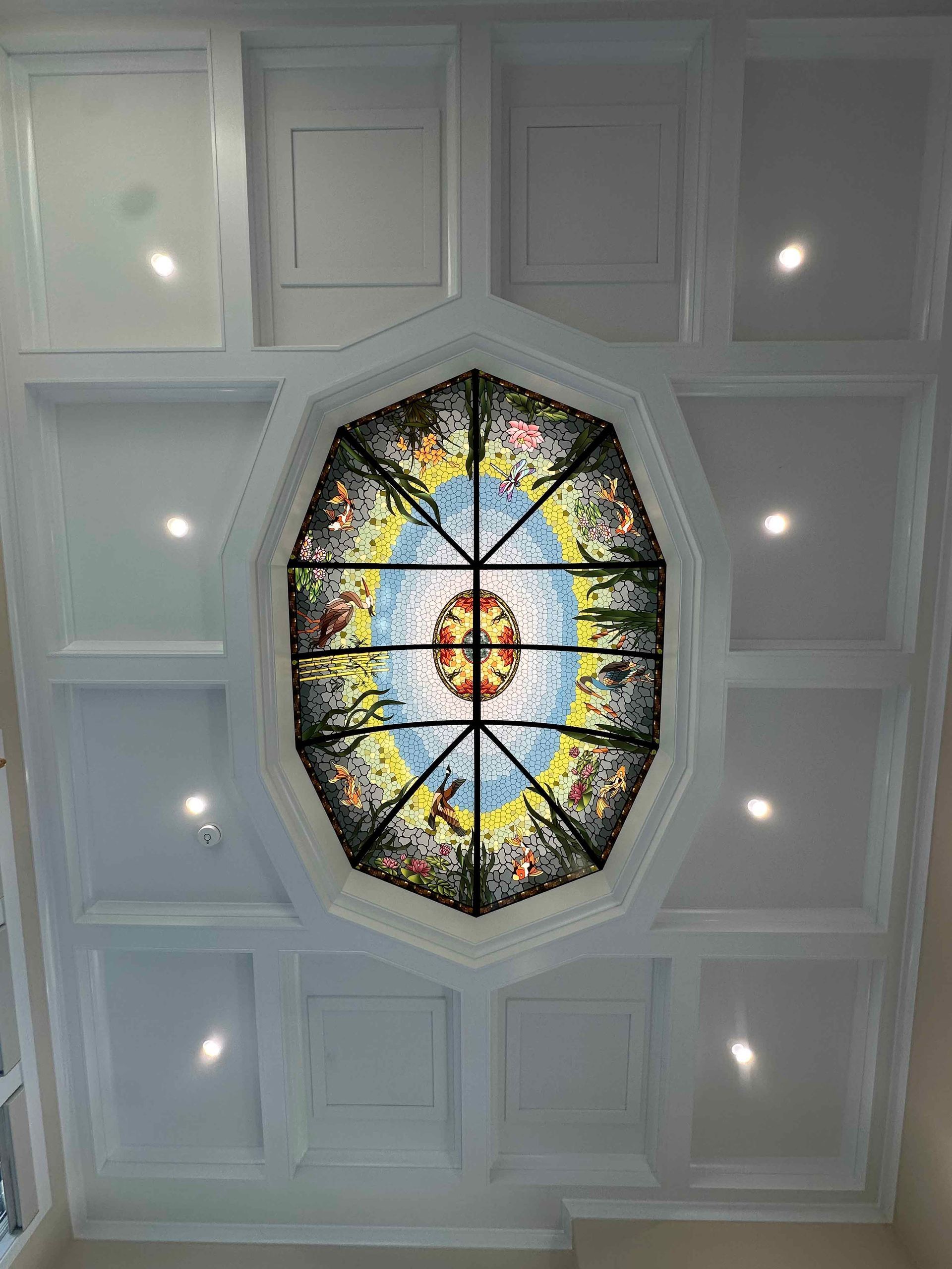 A stained glass window is hanging from the ceiling of a room.