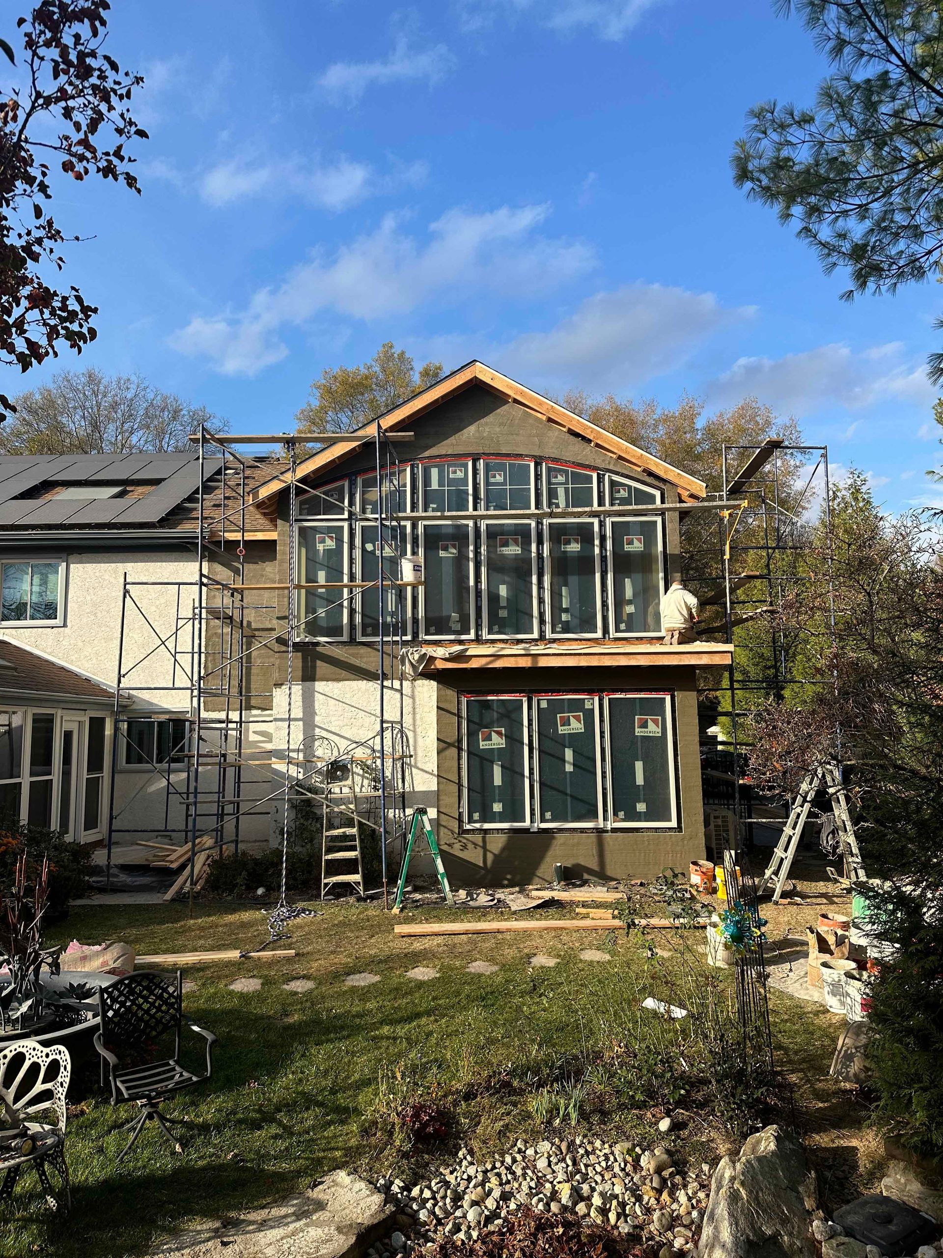 A house is being remodeled with a lot of windows and scaffolding.