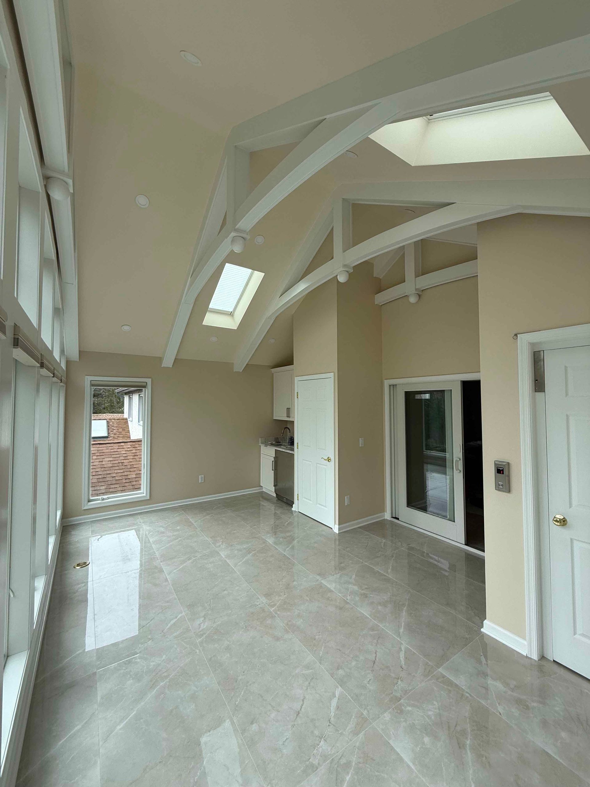 A large empty room with a lot of windows and a skylight.