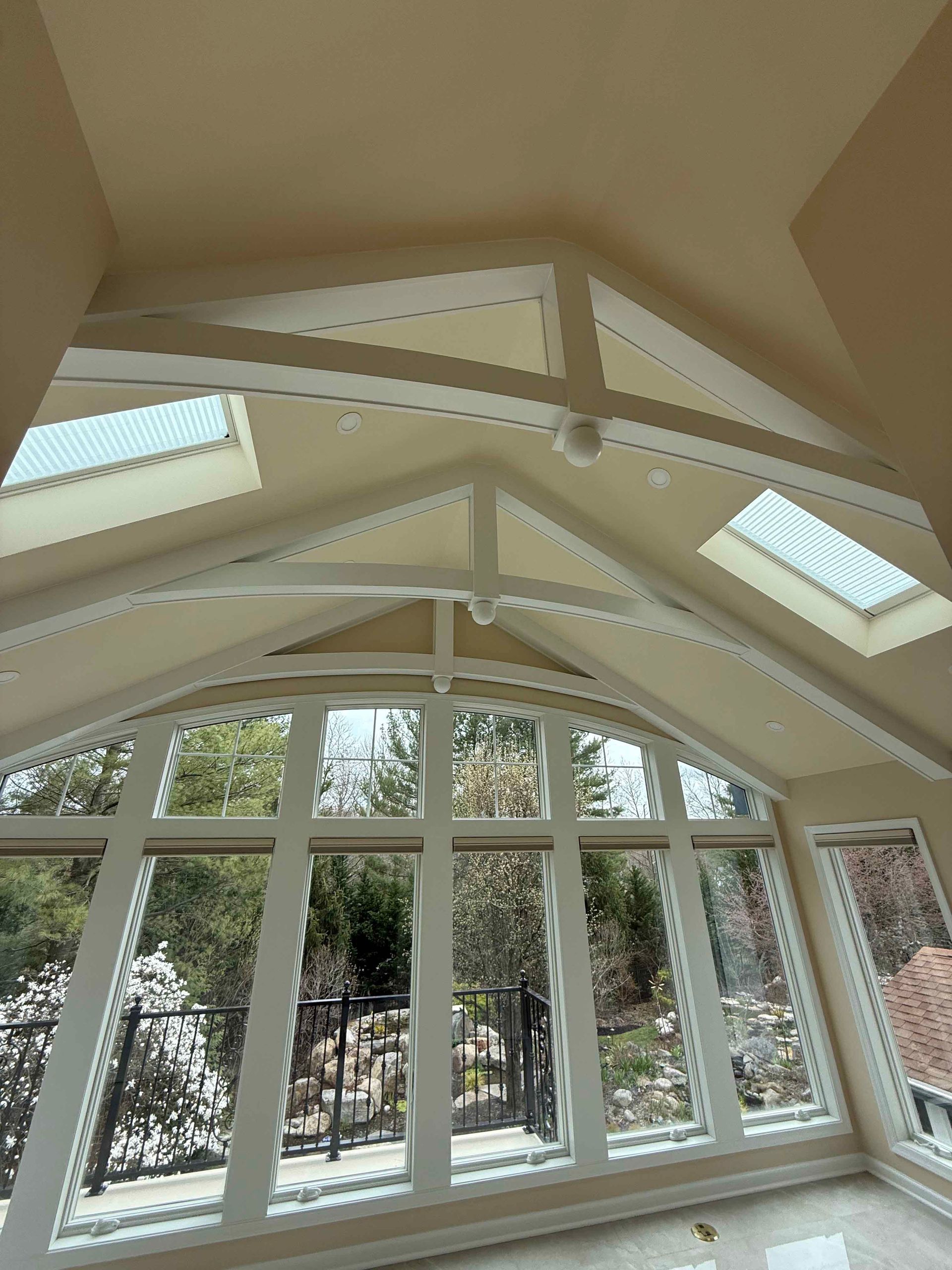 A room with a vaulted ceiling and lots of windows