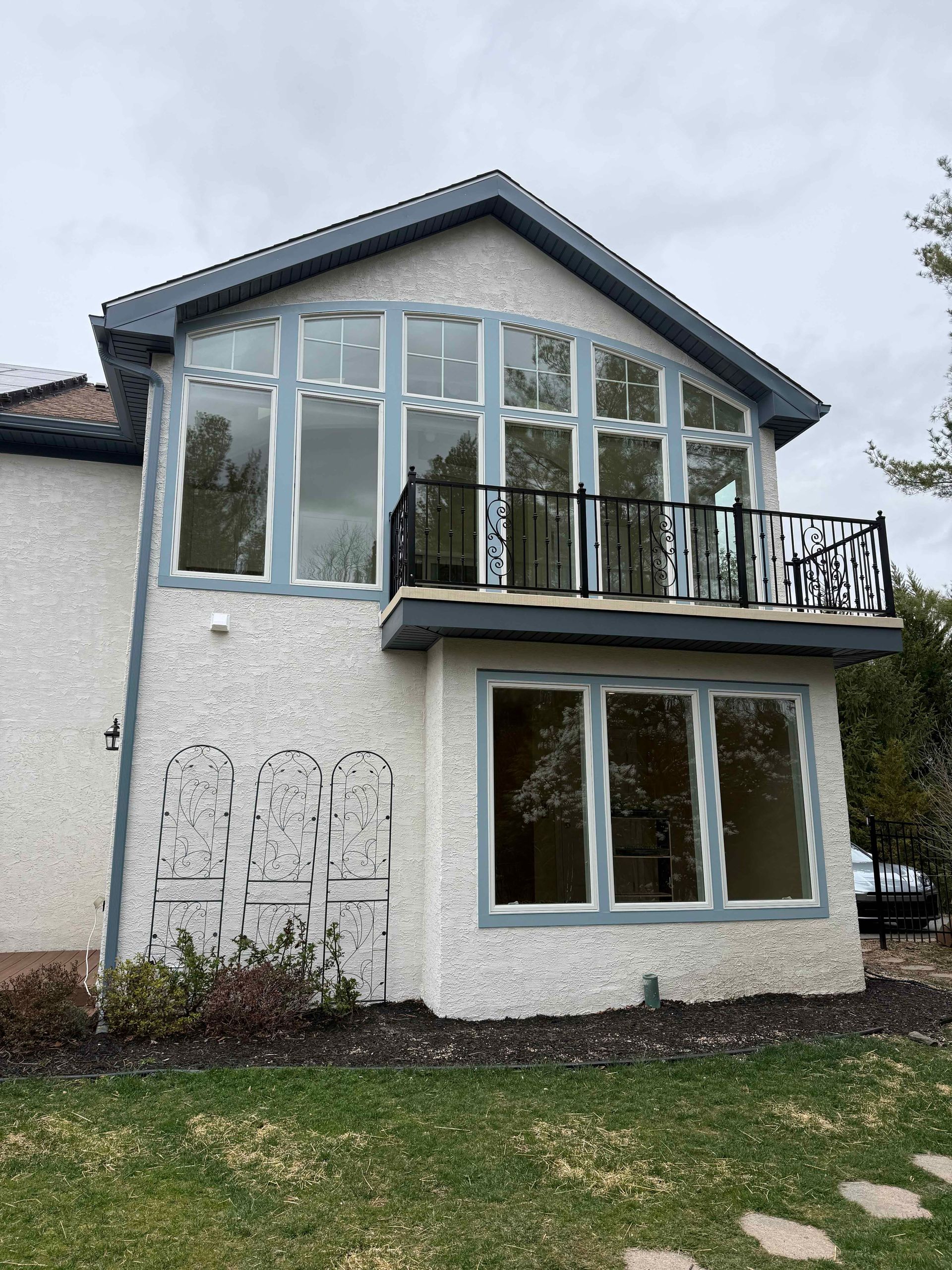A large white house with a balcony and lots of windows.