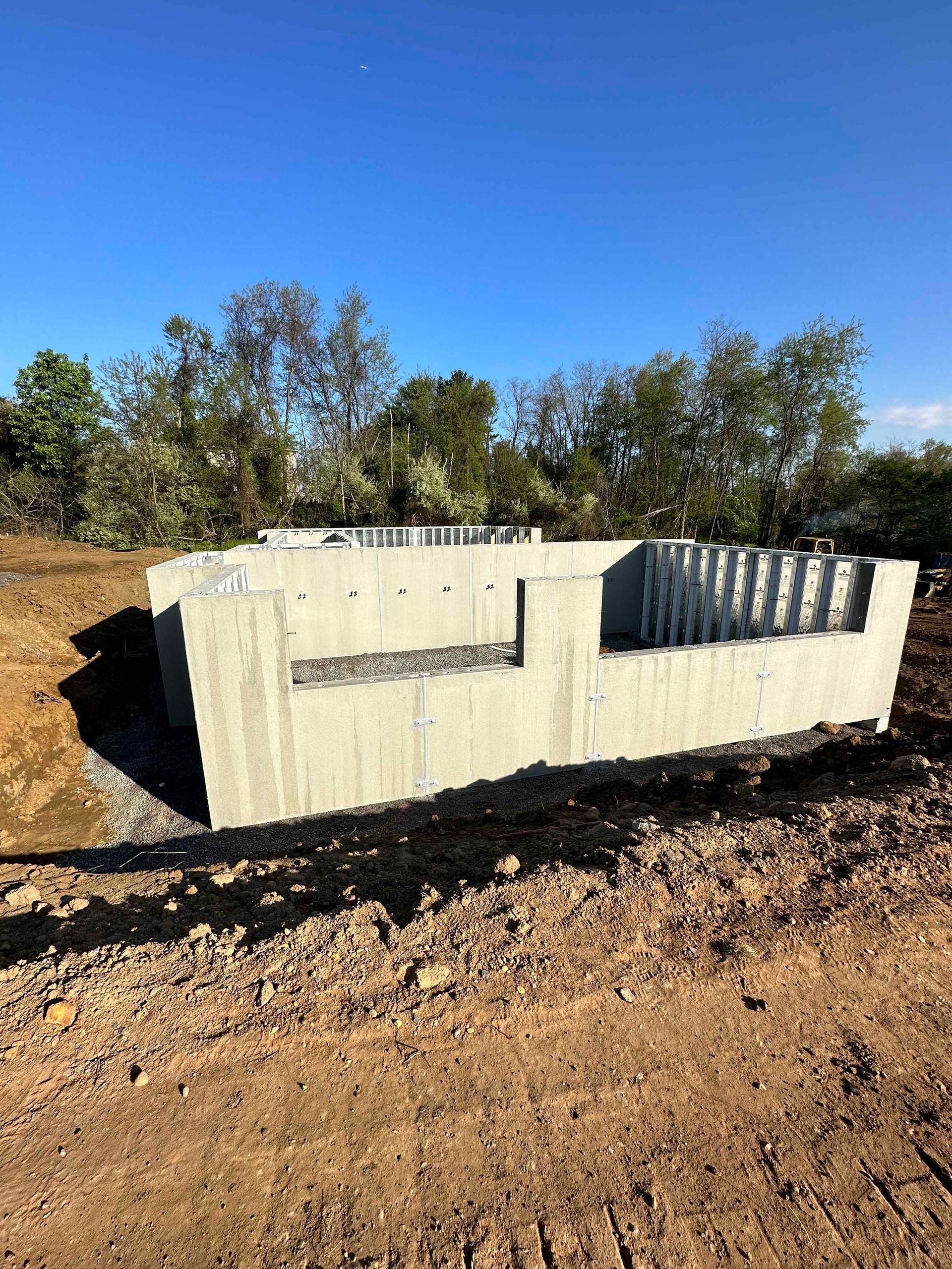 A large concrete block is sitting in the middle of a dirt field.