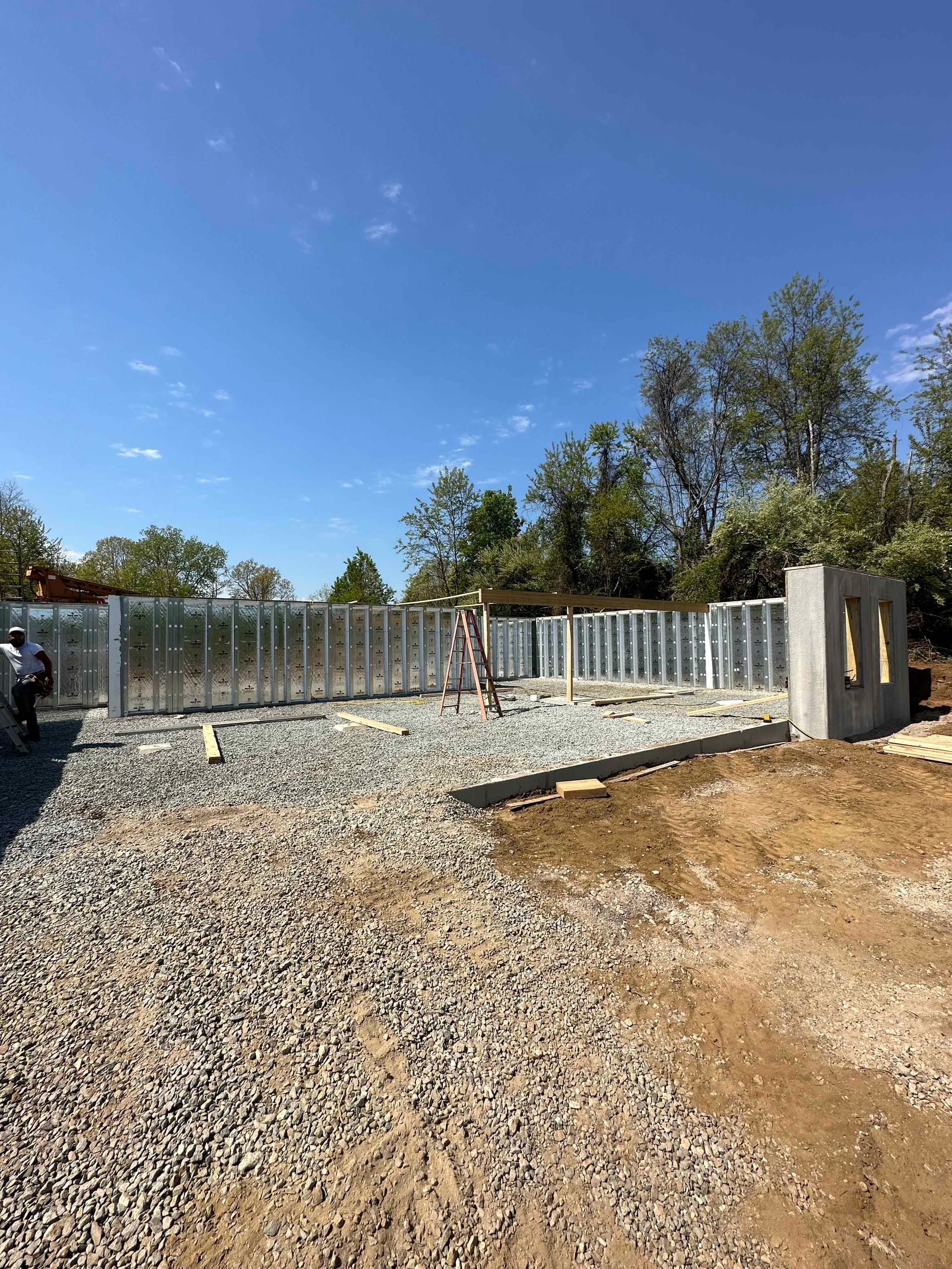 A gravel road leading to a building under construction.