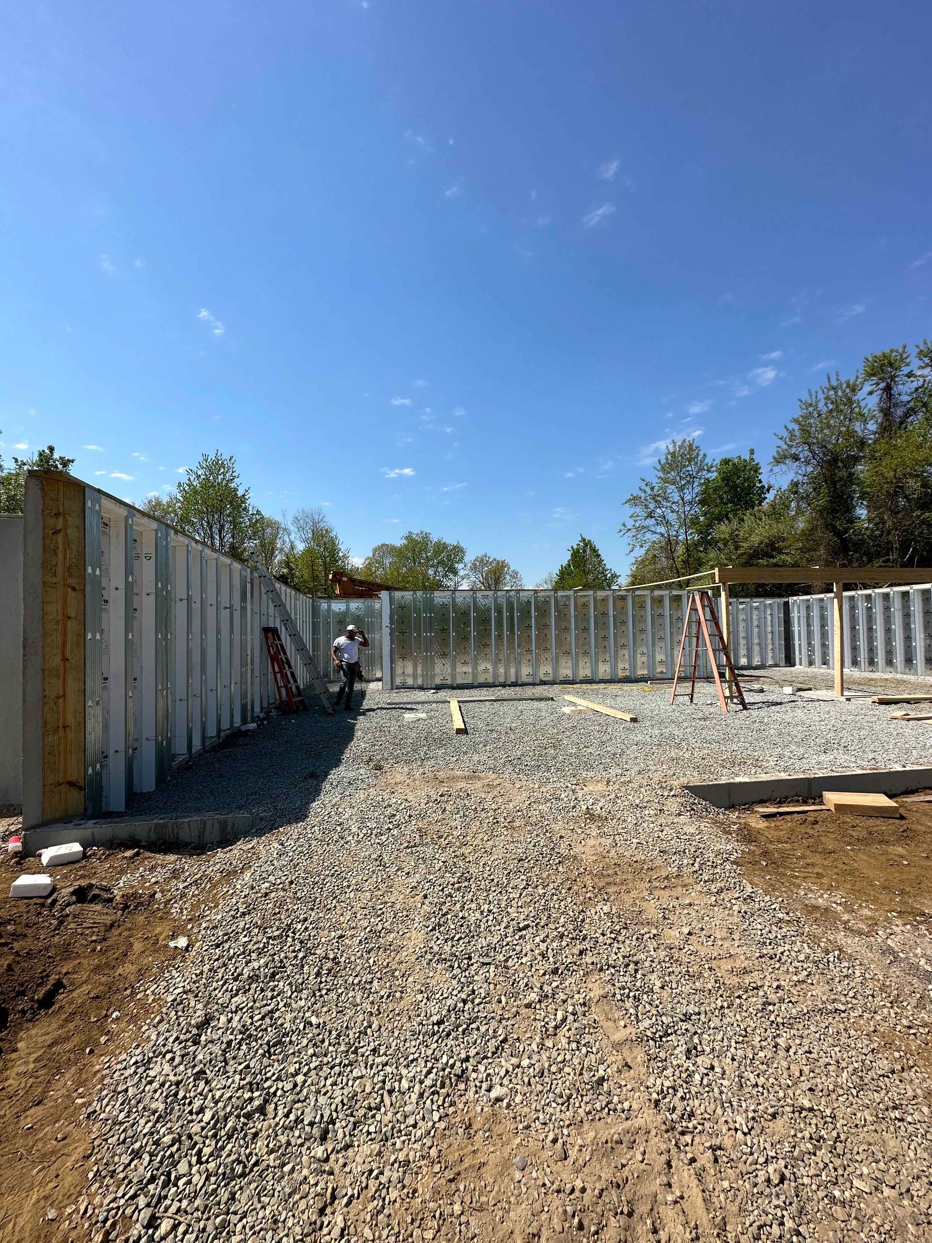 A gravel road leading to a building under construction.