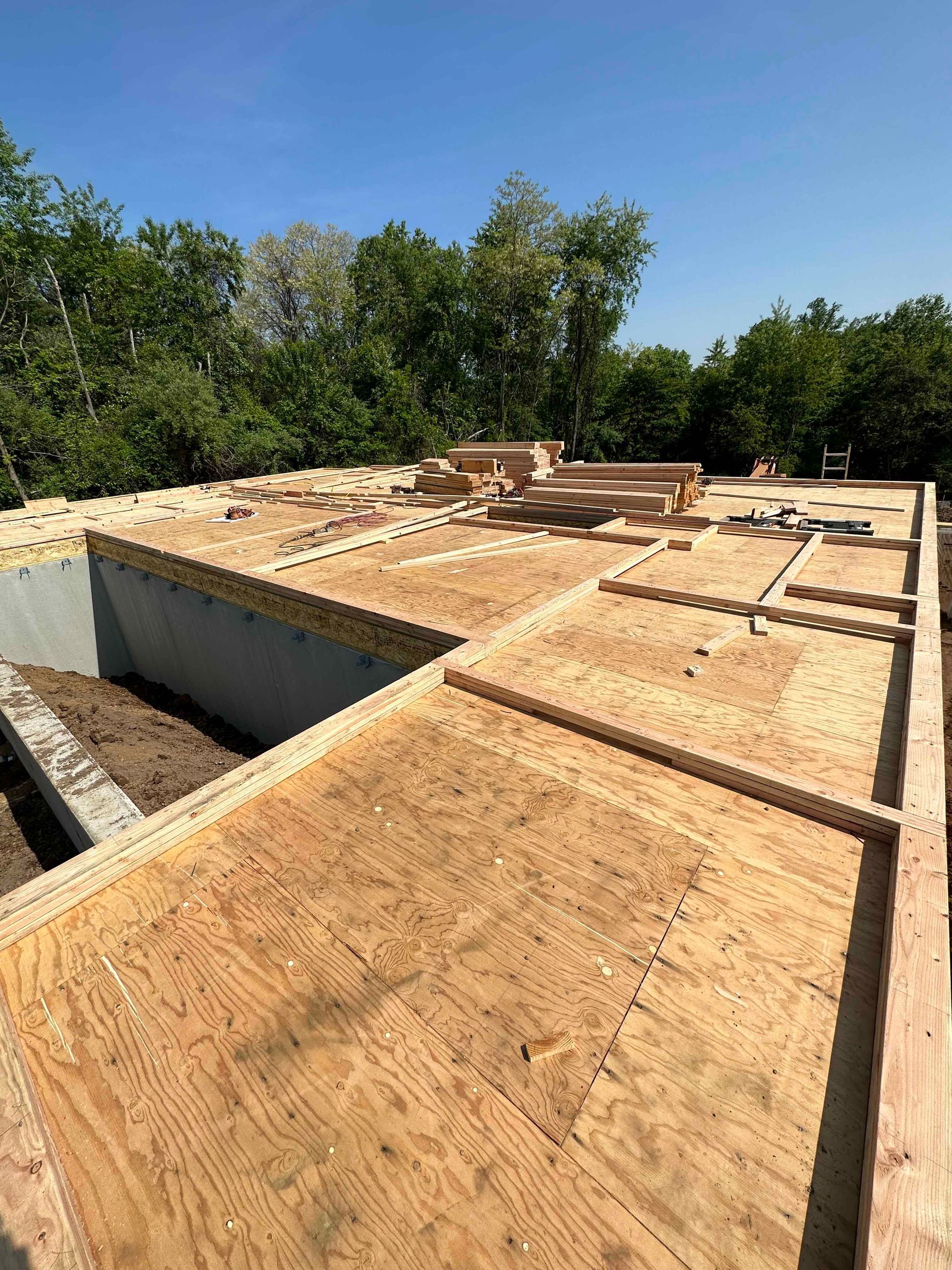 The roof of a house is being built and is covered in plywood.