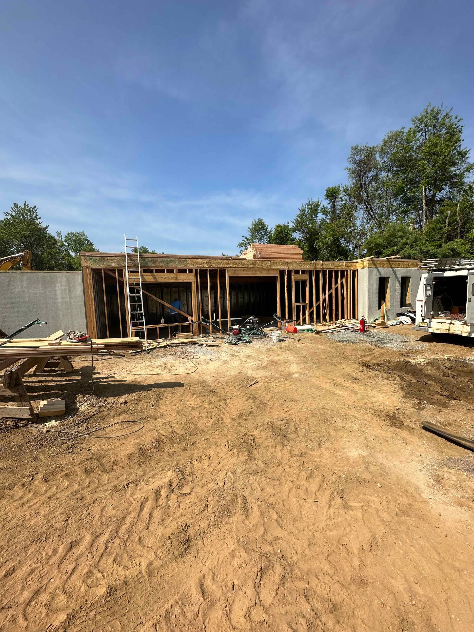 A large house is being built in a dirt field.