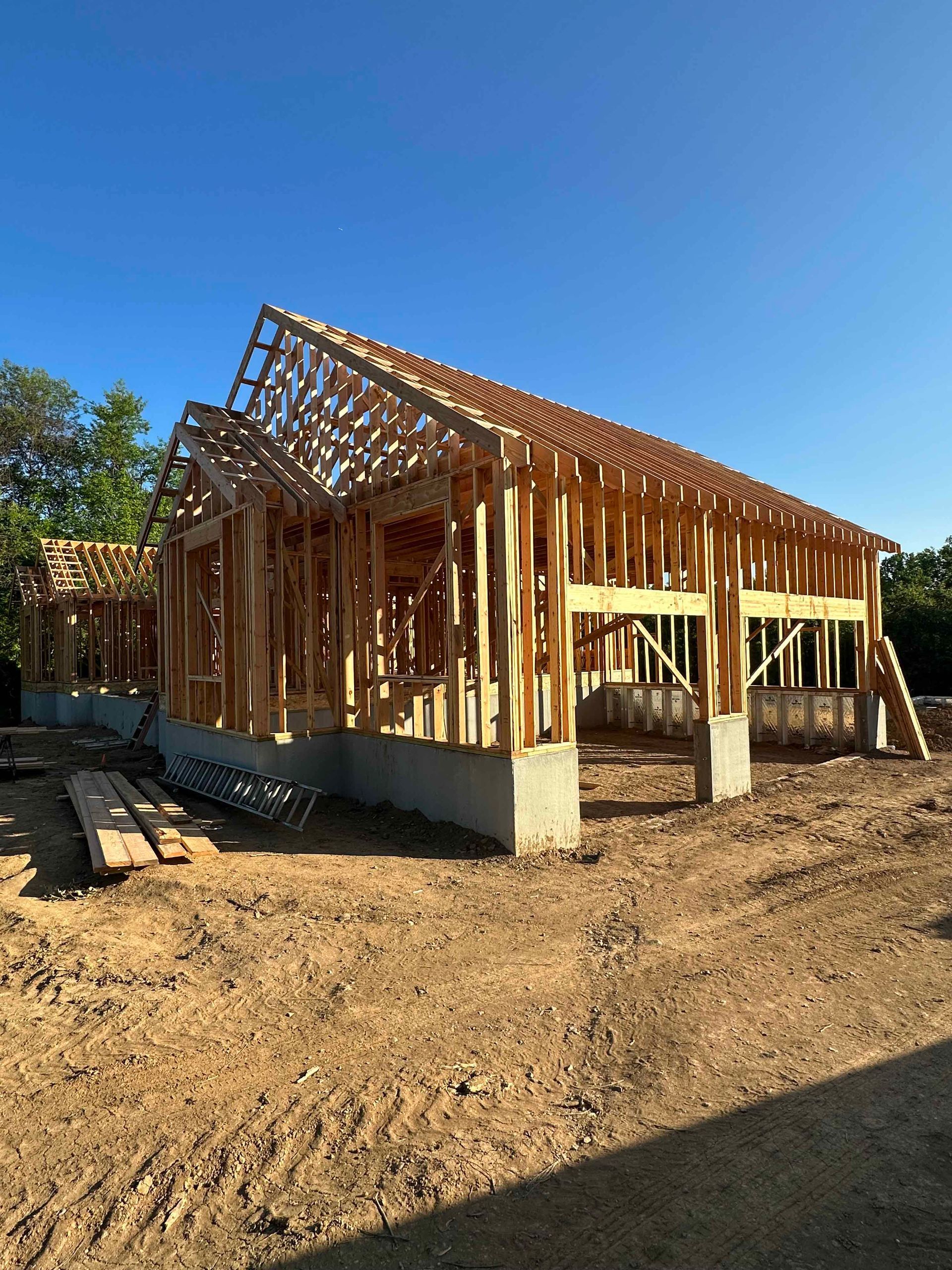 A house is being built in the middle of a dirt field.