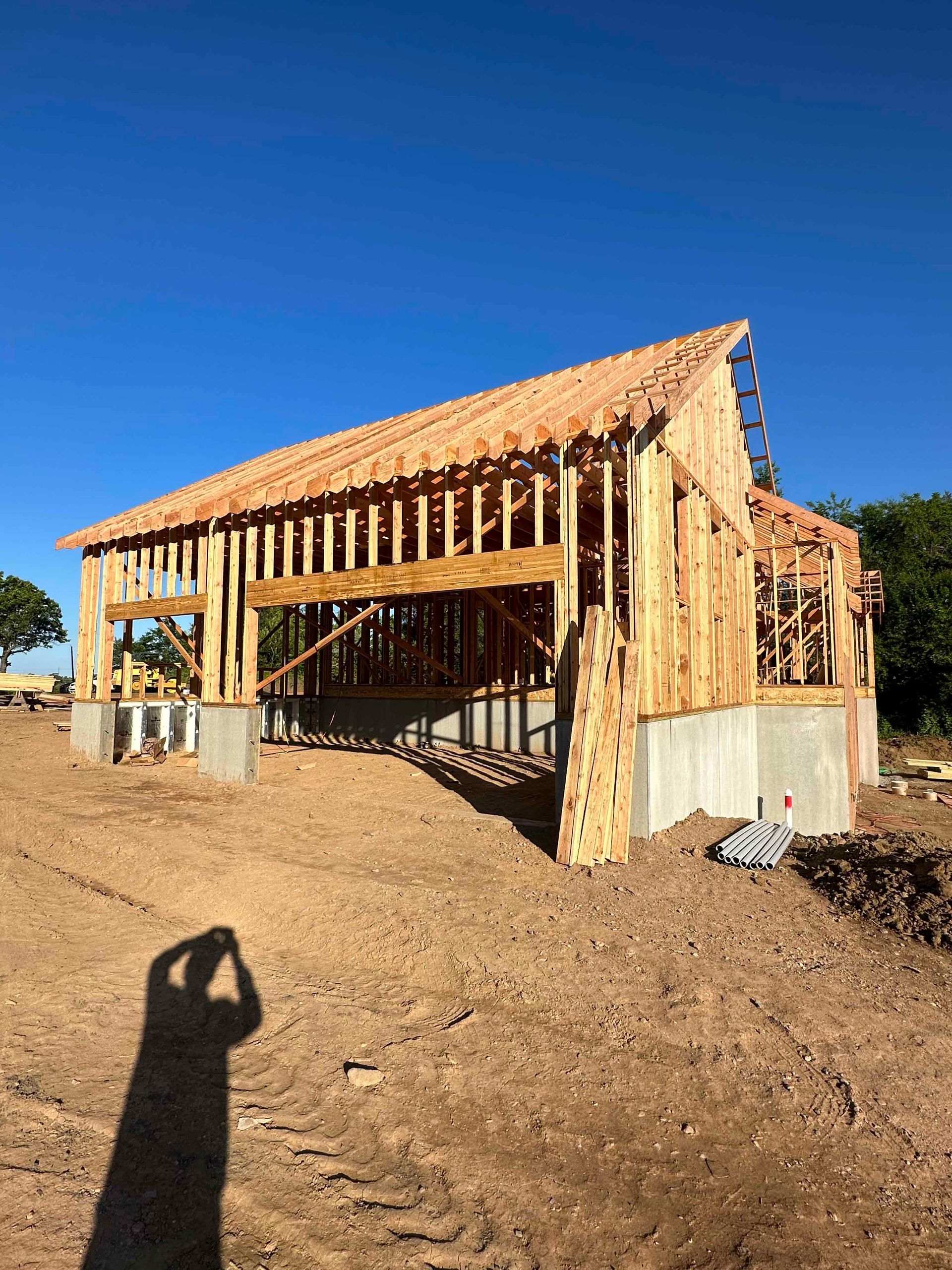 A wooden structure is being built in a dirt field.