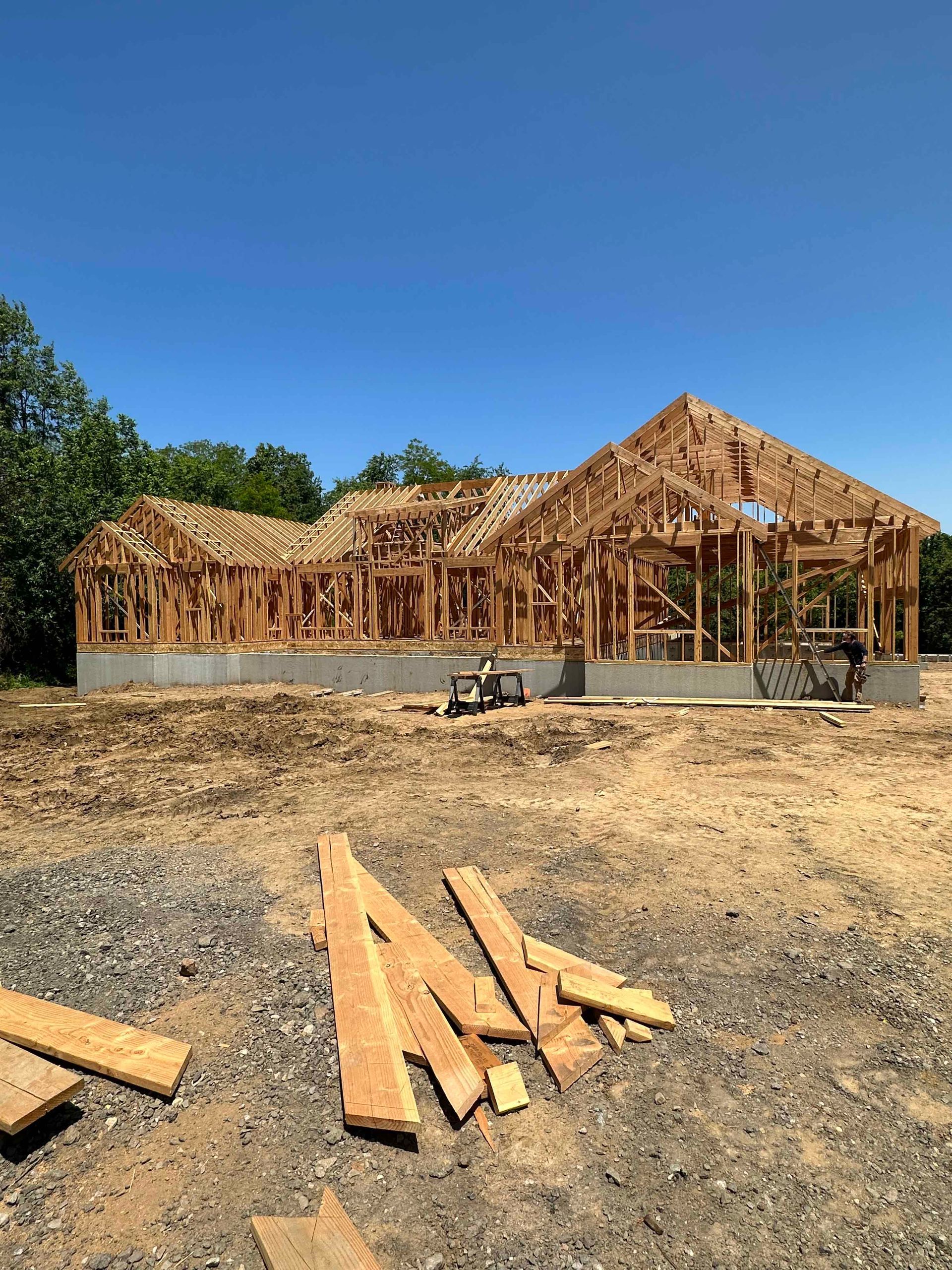 A house is being built in the middle of a dirt field.