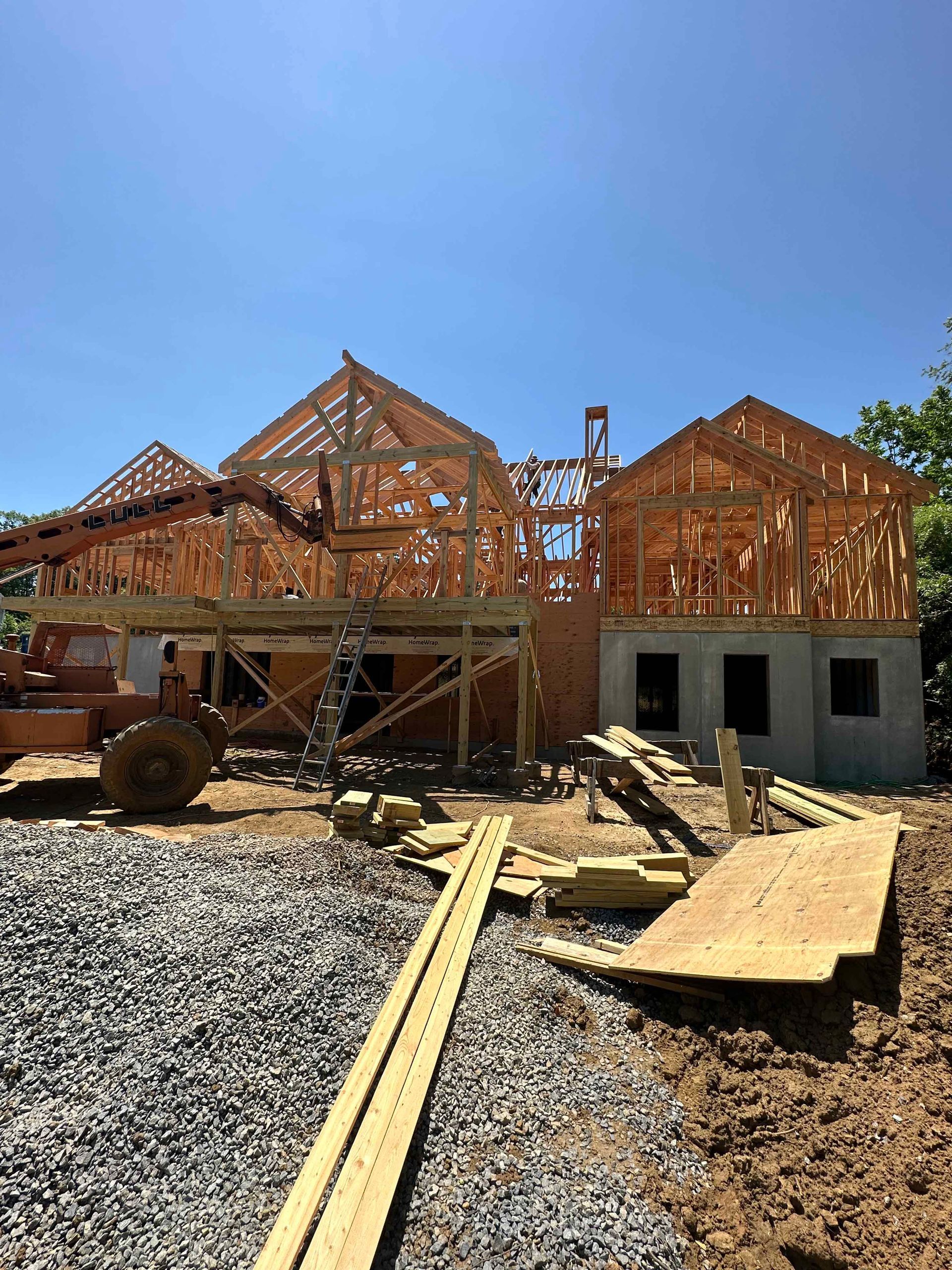 A house is being built in the middle of a dirt field.