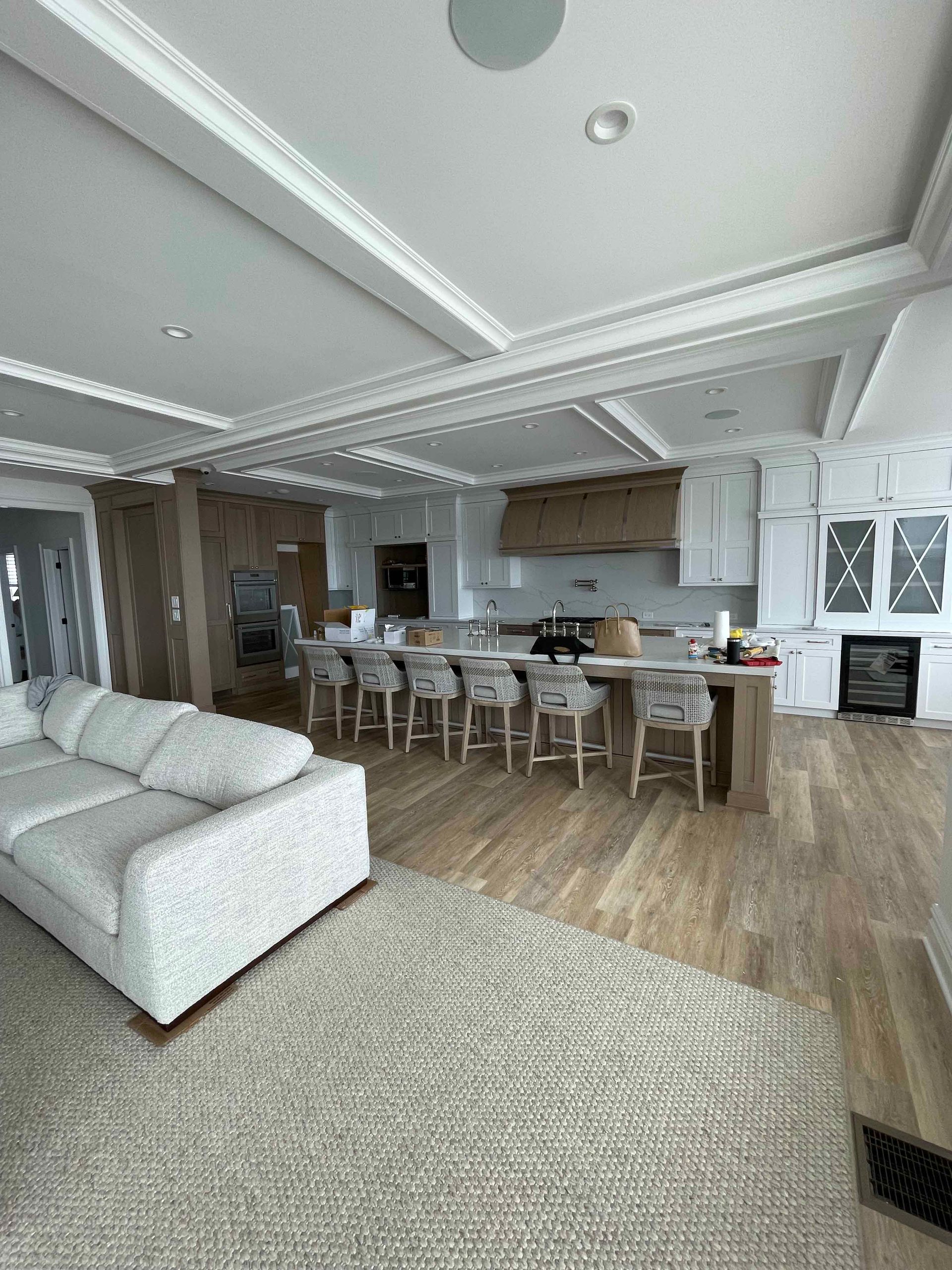 A living room with a couch and a kitchen in the background.