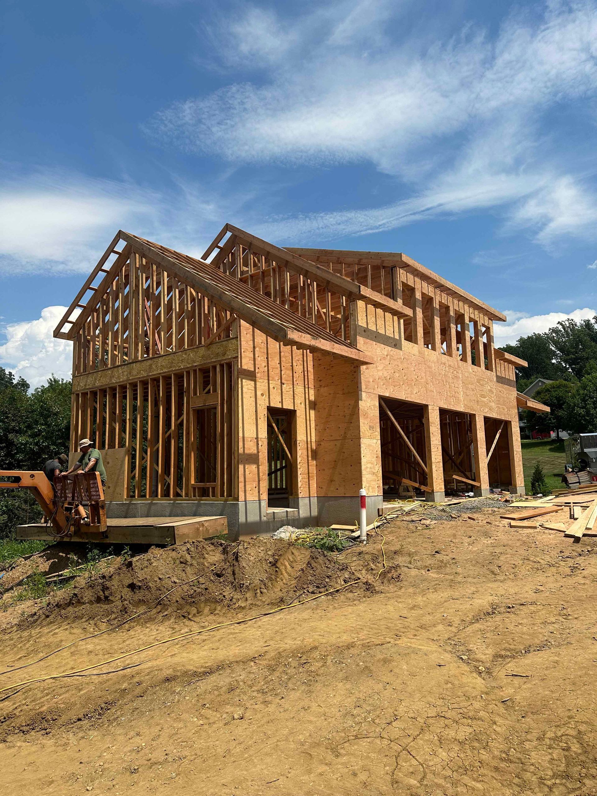 A house is being built in the middle of a dirt field.