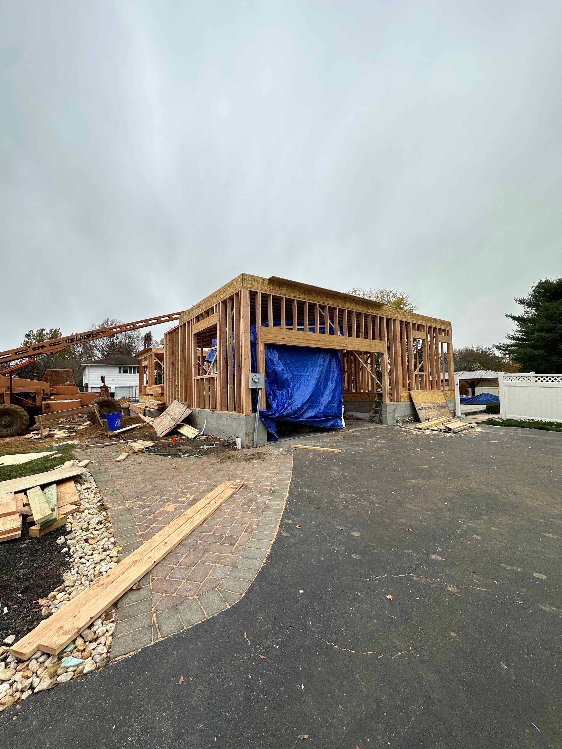 A house is being built in the middle of a driveway.