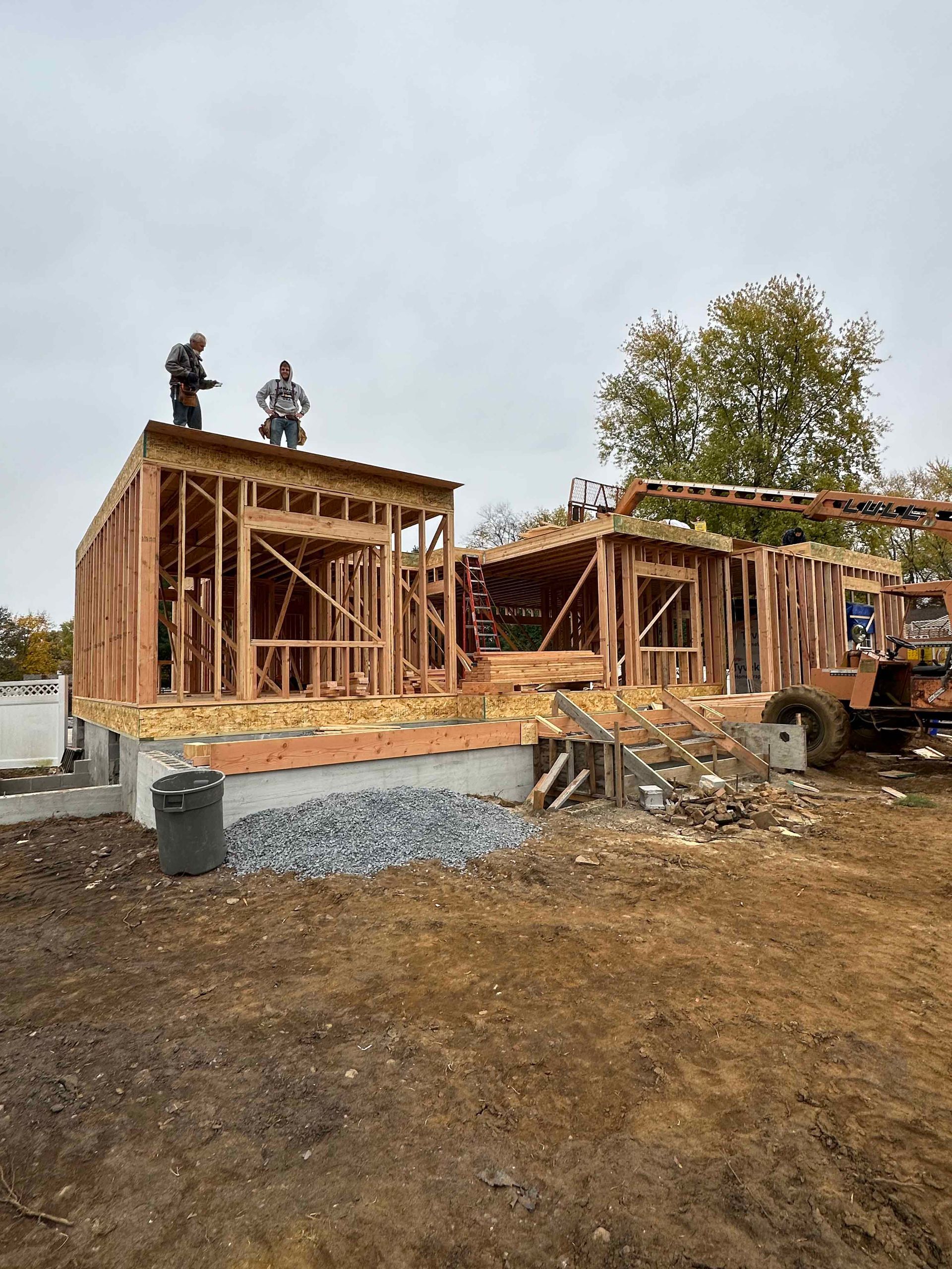 A house is being built in a dirt field.