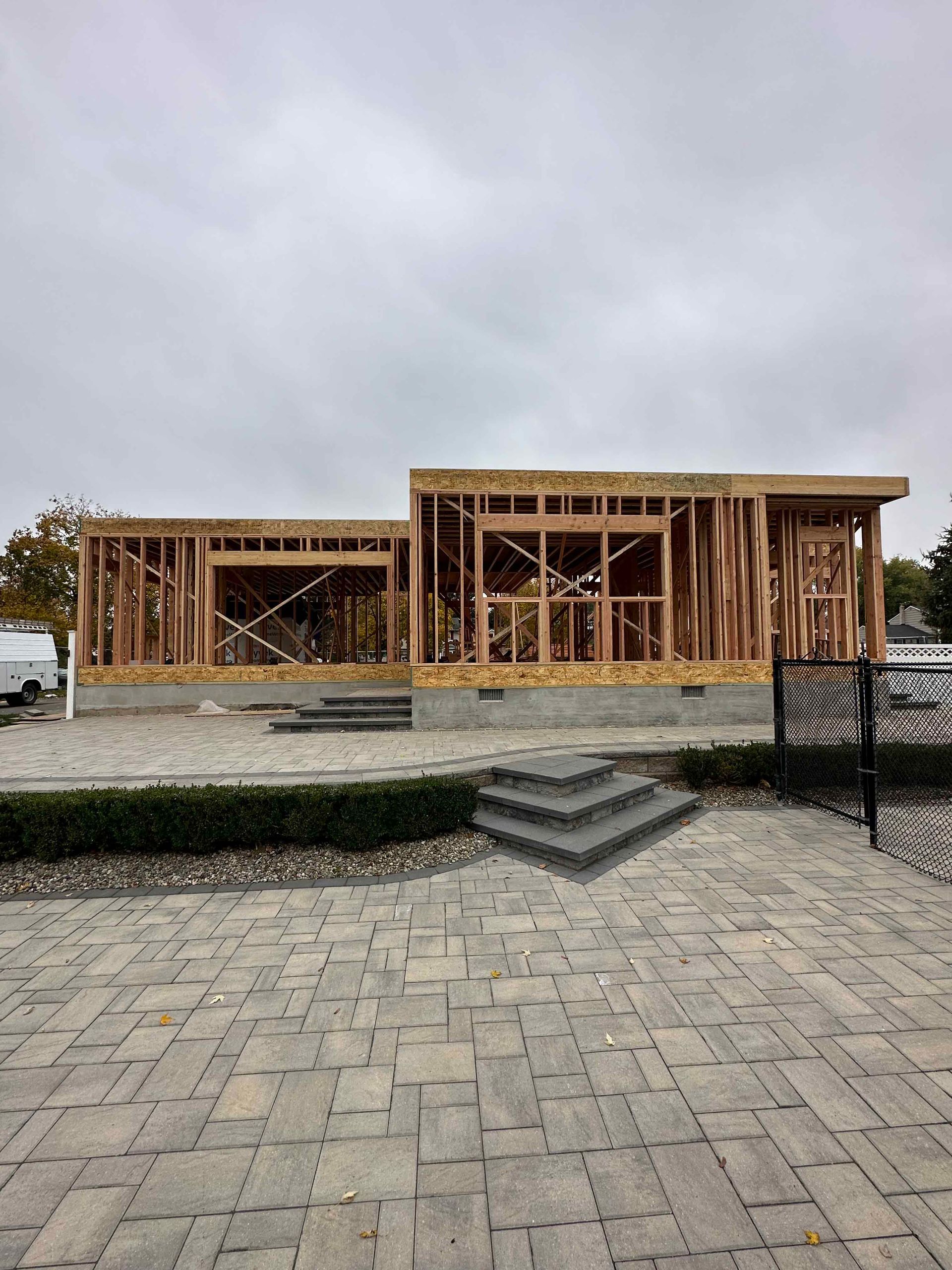 A house is being built on a brick driveway.