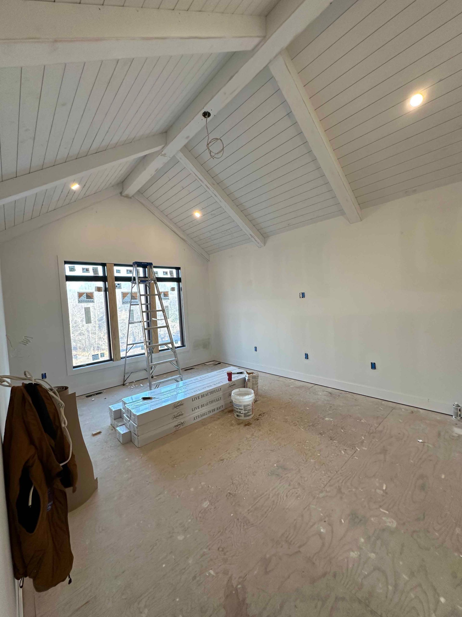 A large empty room with white walls and a vaulted ceiling.