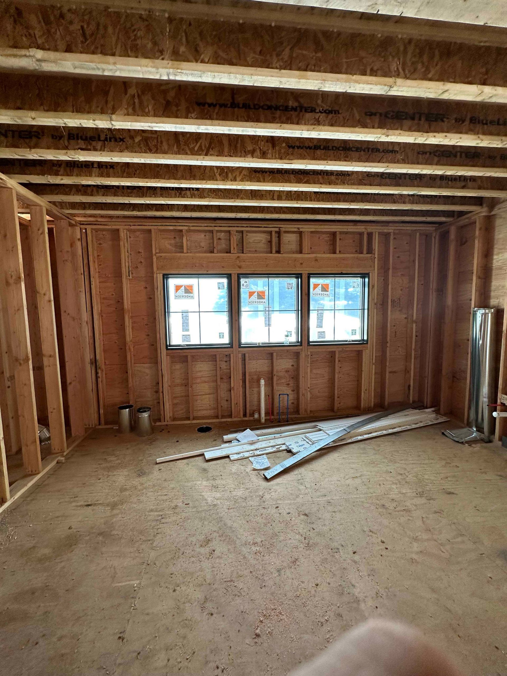 A room with a lot of windows and wooden beams.