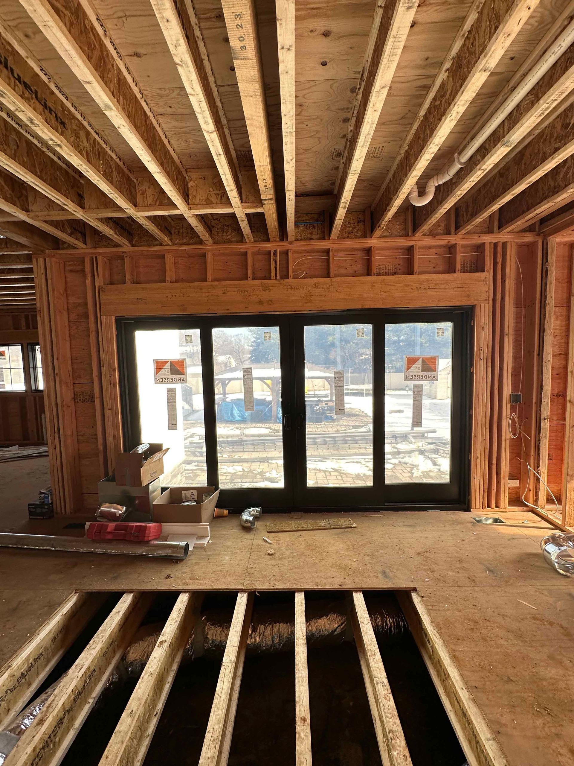 A room in a house under construction with a lot of windows.