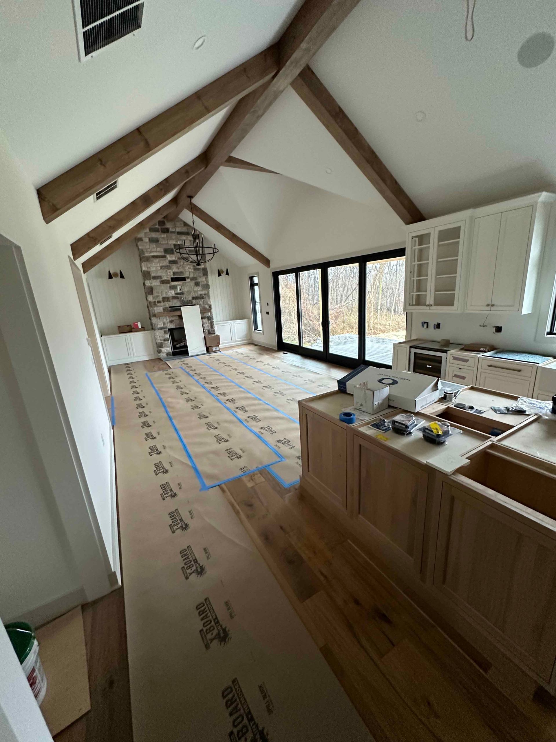 A kitchen is being remodeled with wooden cabinets and a fireplace.