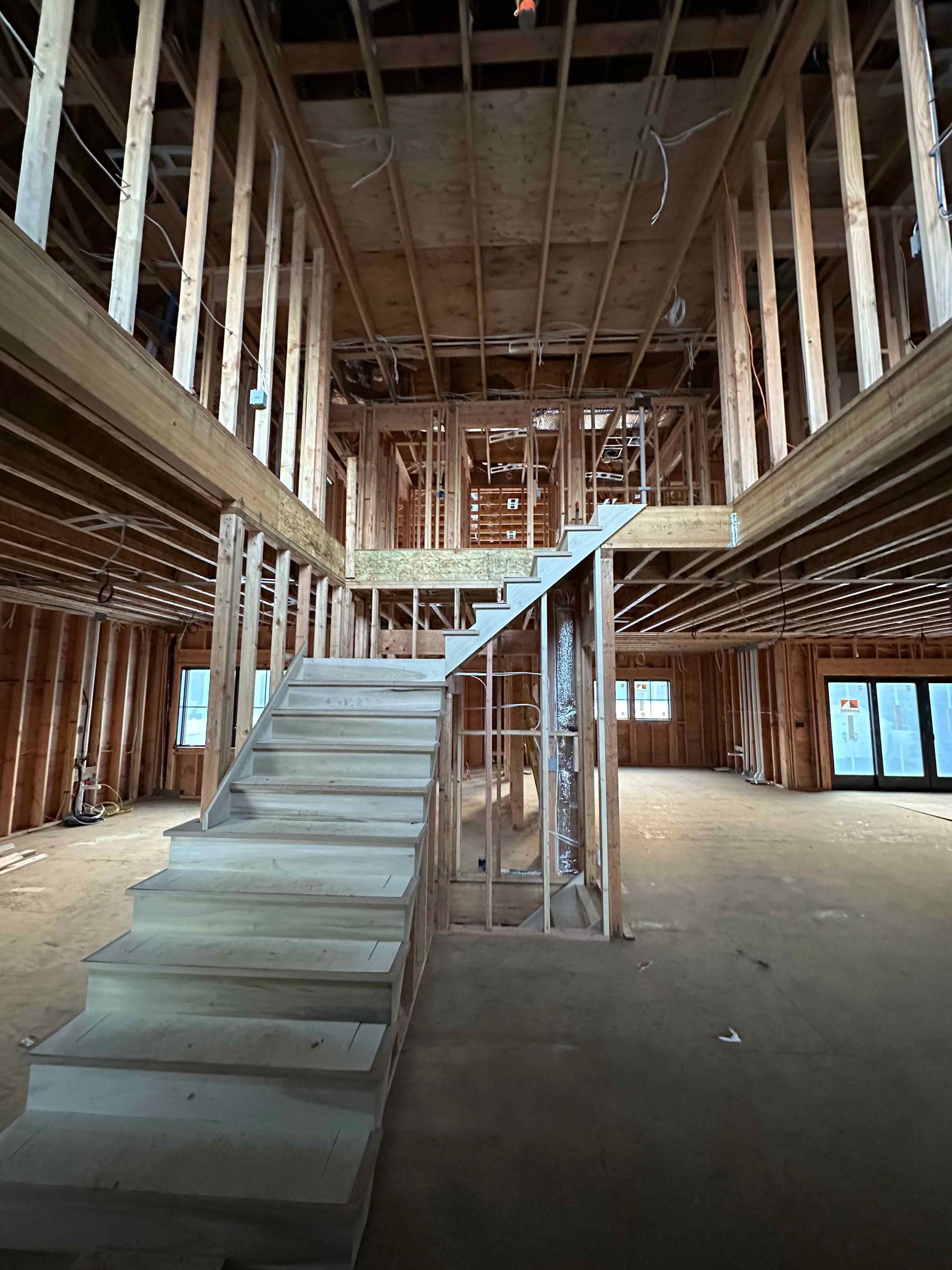 A building under construction with stairs going up to the second floor