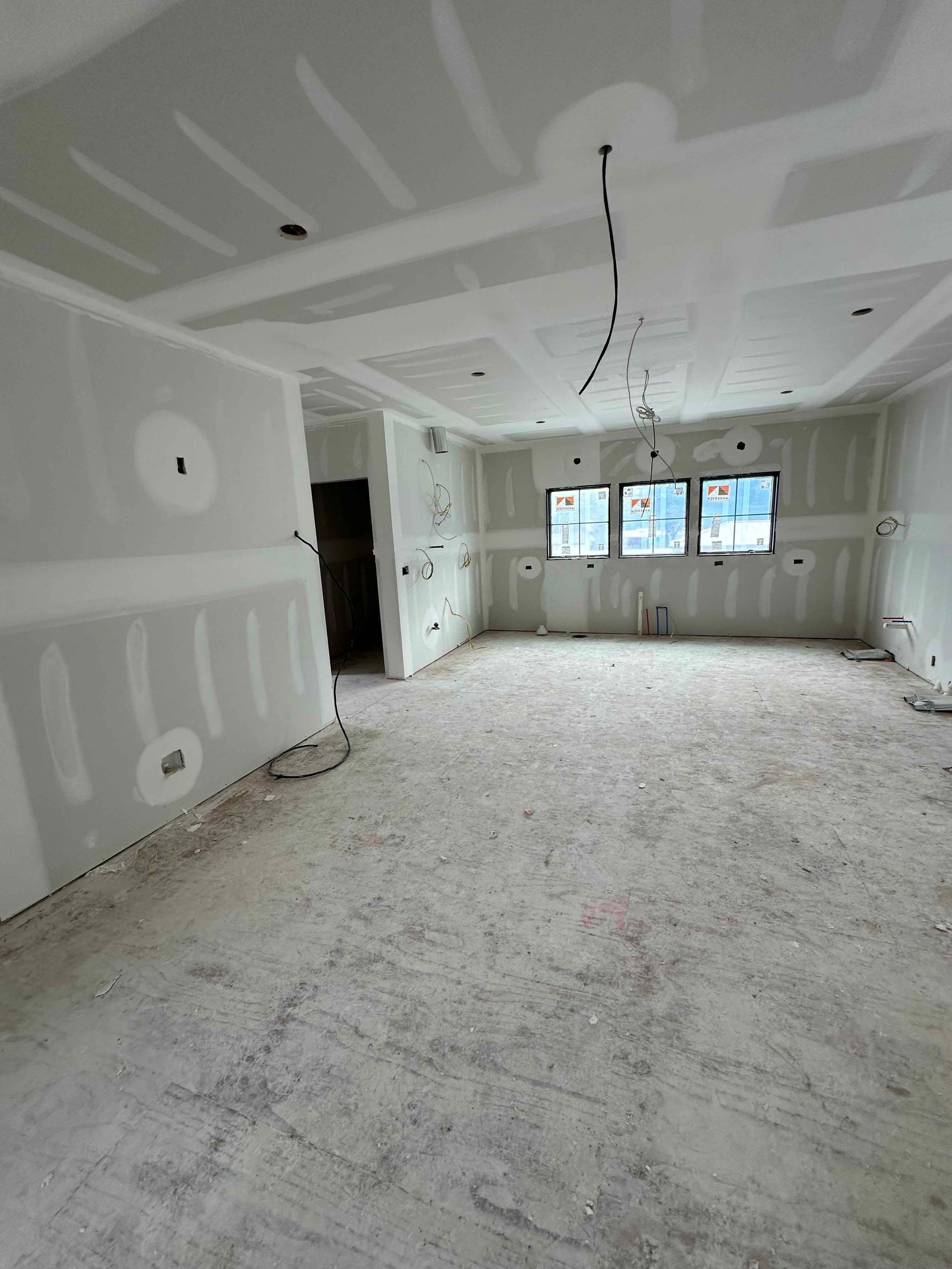 A large empty room with drywall on the walls and floor.