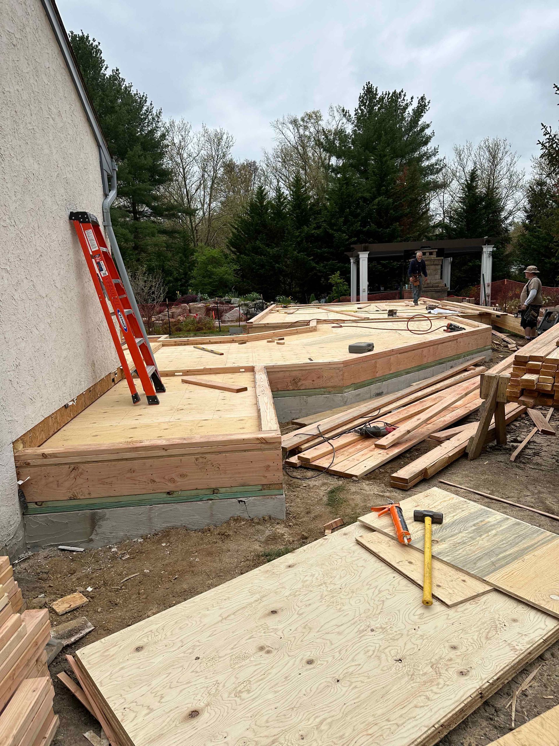 A ladder is sitting on top of a pile of wood.