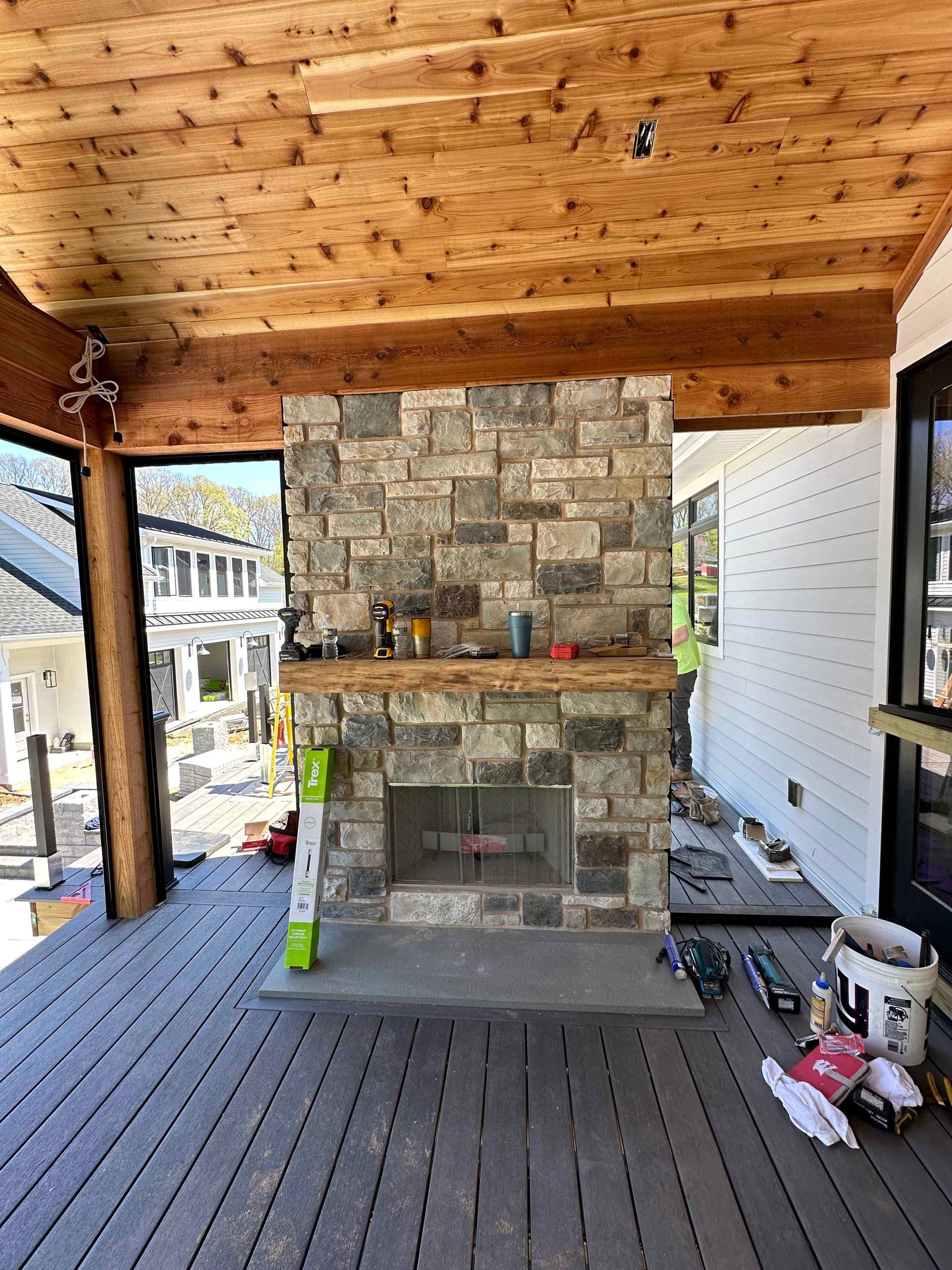 A stone fireplace is sitting on top of a wooden deck.