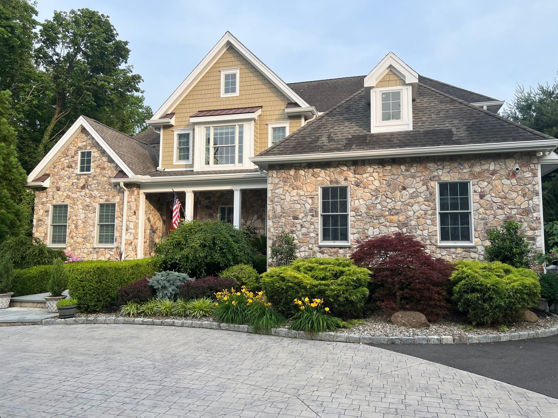 A large stone house with a driveway in front of it
