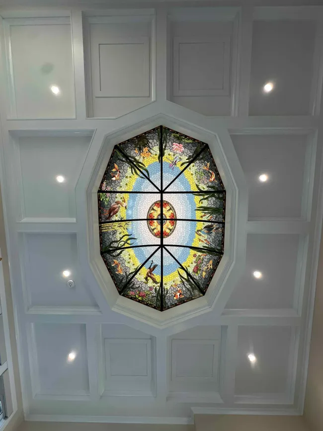 A ceiling with a stained glass window in the middle of it.
