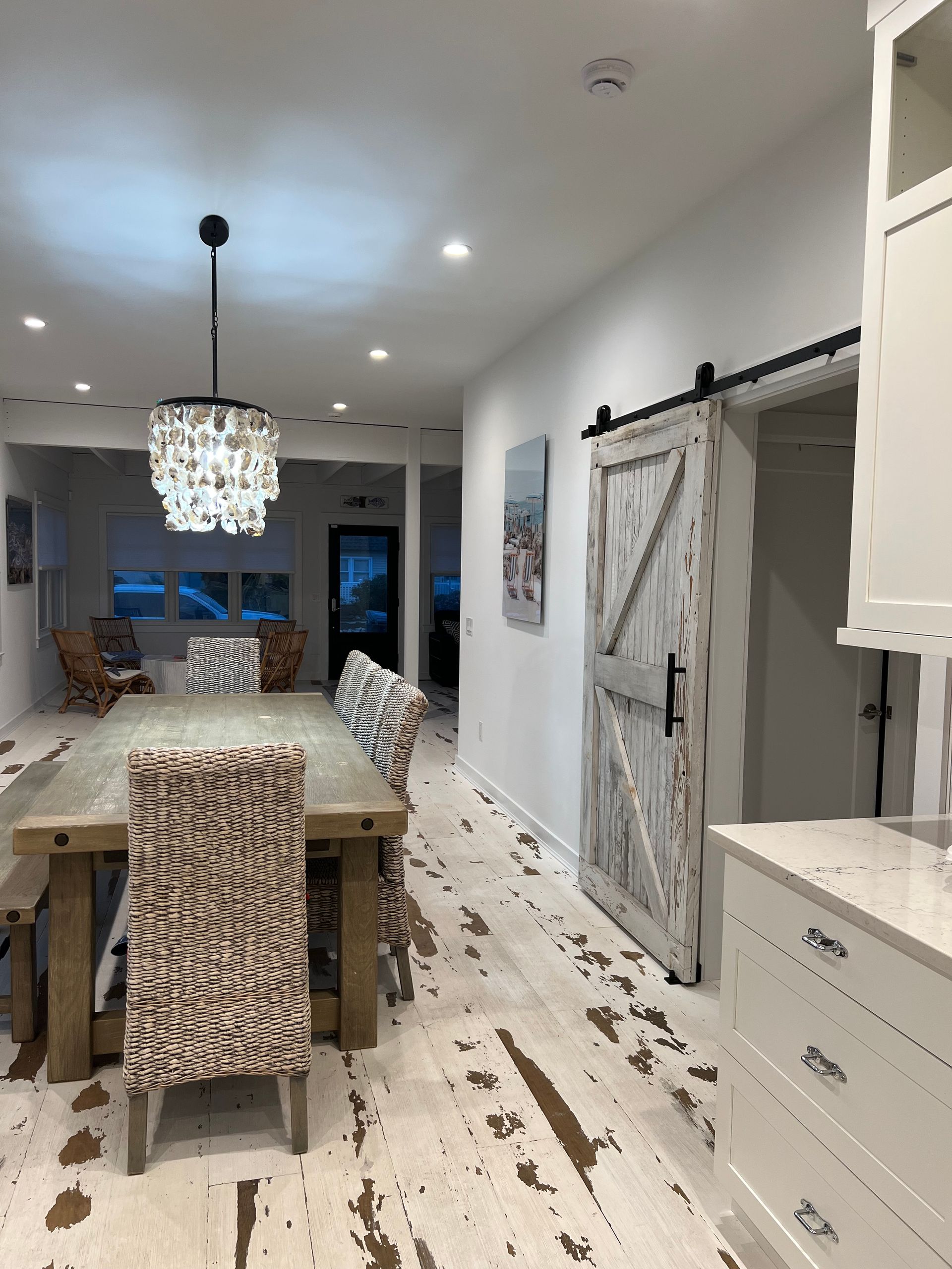 A dining room with a table and chairs and a sliding barn door