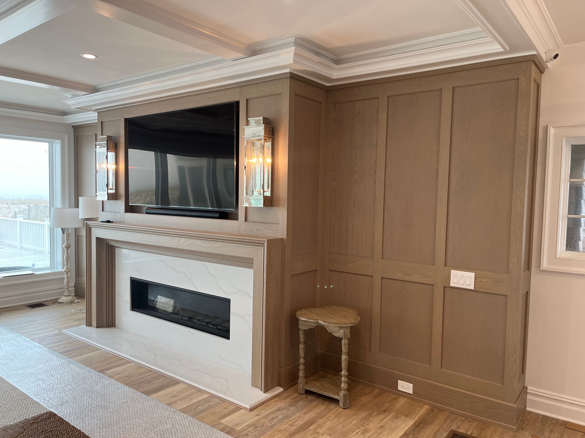 A living room with a fireplace and a flat screen tv on the wall.