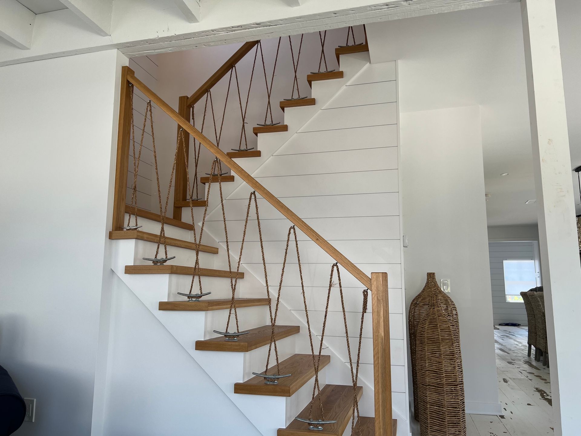 A white staircase with wooden steps and a wooden railing