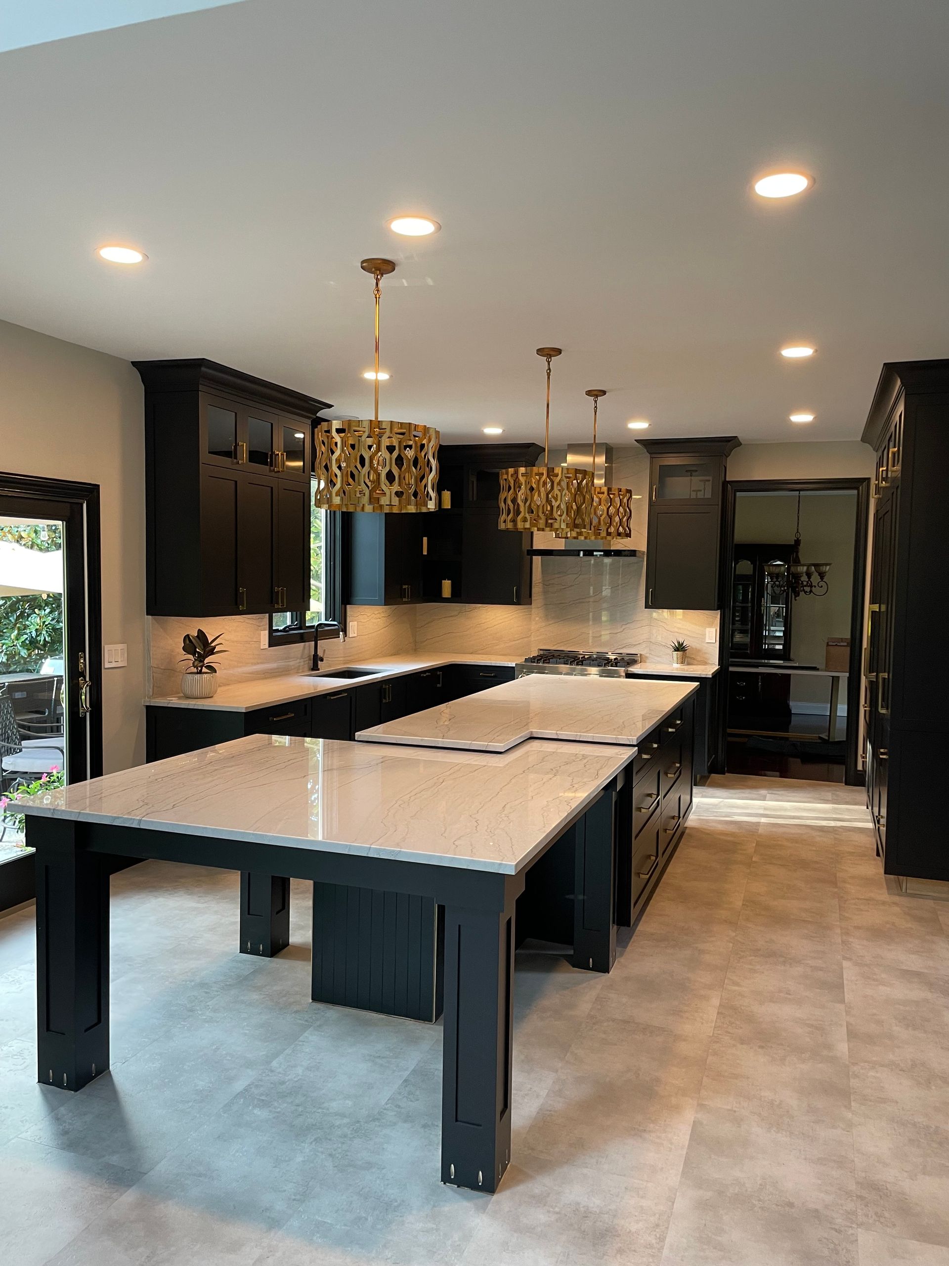A kitchen with a long table and black cabinets